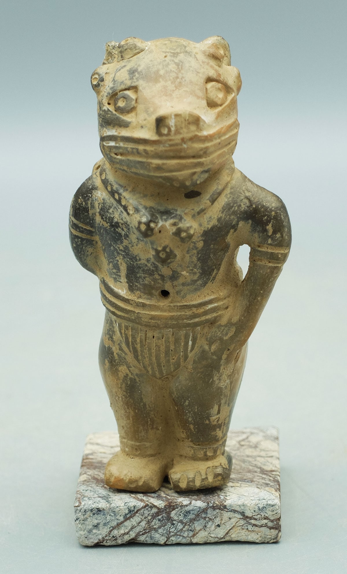 Tairona Whistle - Colombia: A fine Tairona whistle from Colombia, ca. 1000 - 1500 AD. This unusual figure is 4-1/4 in. high and depicts a feline deity wearing a loincloth. He is adorned with a necklace holding a trio of cactus b
