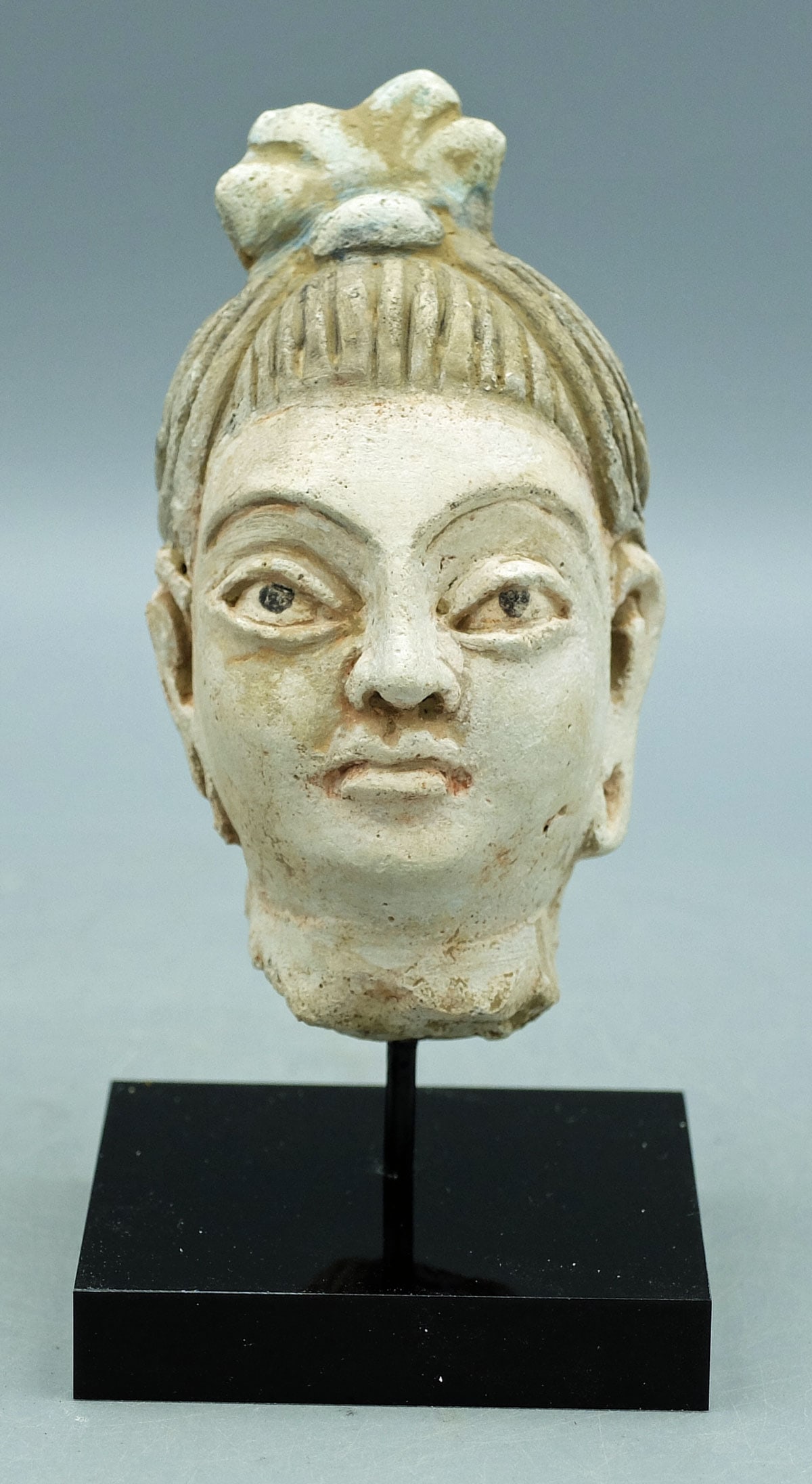 Gandharan stucco head - the Indus Valley: A choice Gandharan stucco head from the Indus Valley, ca. 4th - 5th Century AD. This large example is 4 in. high and portrays a Bodhisattva with elongated ears and pierced lobes. His superbly detailed