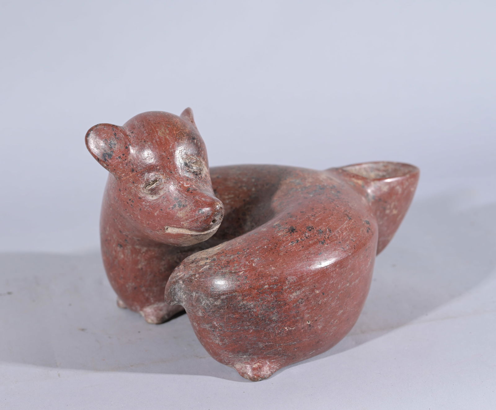 Colima Redware Vessel - Resting Dog: Colima Redware Vessel - Resting Dog Pre-Columbian, West Mexico, Colima. A hand-built and highly burnished redware pottery vessel with a flat base, a horseshoe-shaped body, and a raised head opposite a