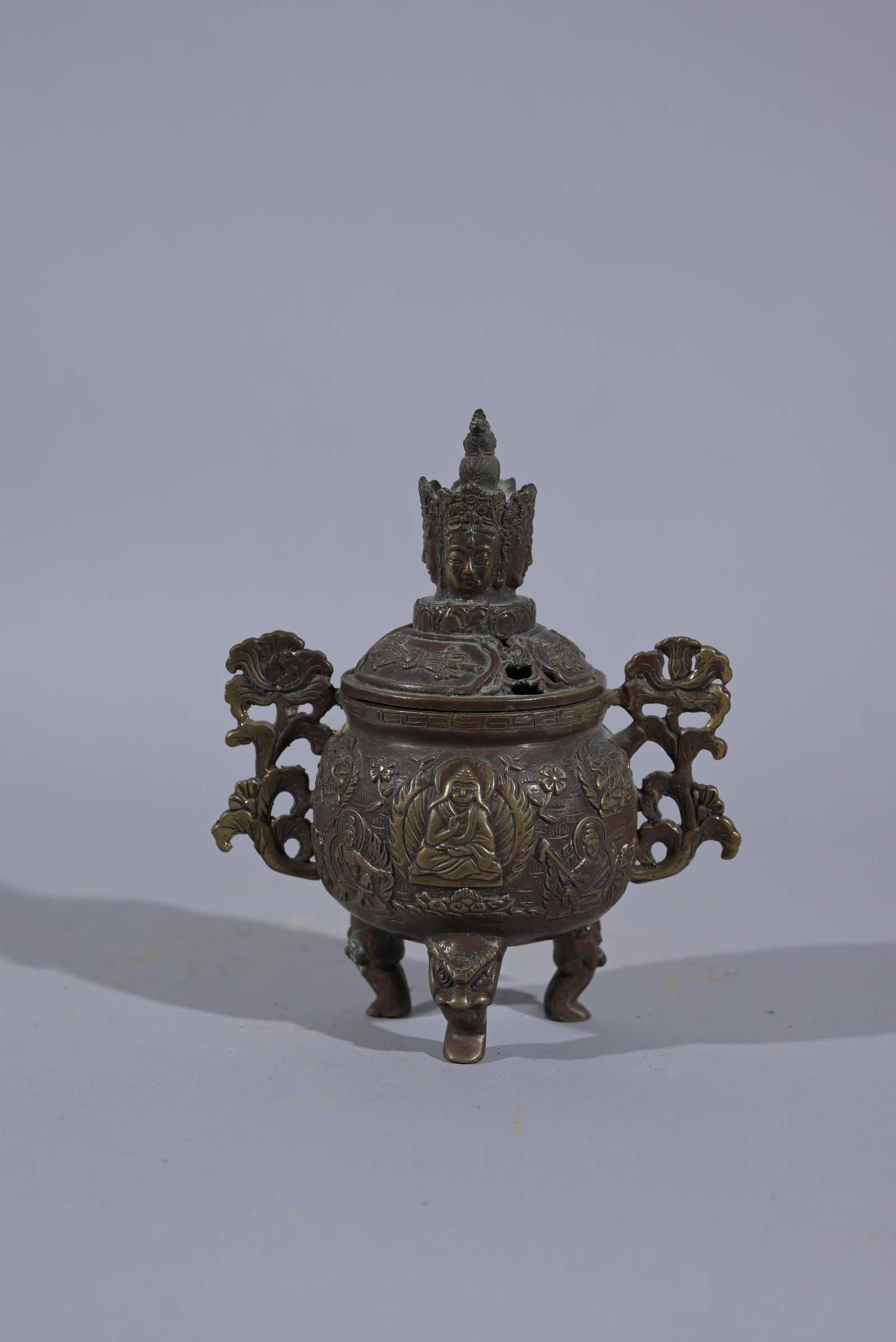 Antique Chinese Bronze Censer w/ Lid: Bronze Lid perforated for the escape of fragrance with top with four faces of Buddha. Body with two handles with floral motifs, presents a Buddhist scene on the central face. Height: 6 in. - Provenanc
