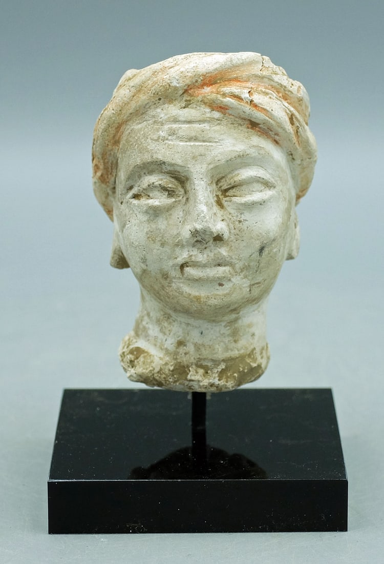 Gandharan stucco head from the Indus Valley: A fine Gandharan stucco head from the Indus Valley, ca. 4th - 5th Century AD. This lovely example is 3 in. high and portrays a youth wearing a wrapped turban. In excellent condition, with good mineral