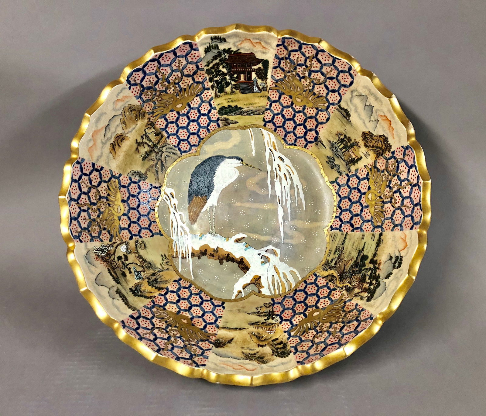 Japanese Satsuma Hand Painted Porcelain Bowl: A Large Japanese Satsuma Hand Painted Porcelain Bowl. Highly decorated with (12) landscapes, (6) landscape painted in the interior, and (6) landscaped painted in the exterior, with a painted large cra