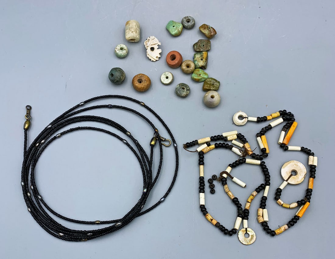 collection of assorted beads: A collection of assorted beads. The group includes an antique 72 in. long Native American necklace comprised of seed and stone beads with the original metal closure; a strand of Native American beads 