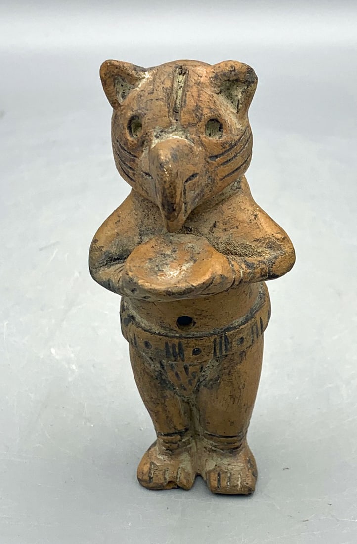 Tairona shamanic 2-note whistle figure - Coloma: A fine Tairona shamanic 2-note whistle figure from Colombia, ca. 1000 - 1500 AD. It is 4 in. high and depicts a shaman wearing a feline mask with bird beak. He is holding an offering bowl and is weari