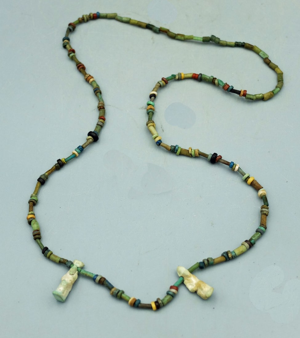 Egyptian faience necklace w/ Pendants: A lovely 21 in. long Egyptian faience necklace with a pair of pendants depicting the Goddess Isis. Her reputed magical power was greater than that of all other gods, and she was said to protect the ki