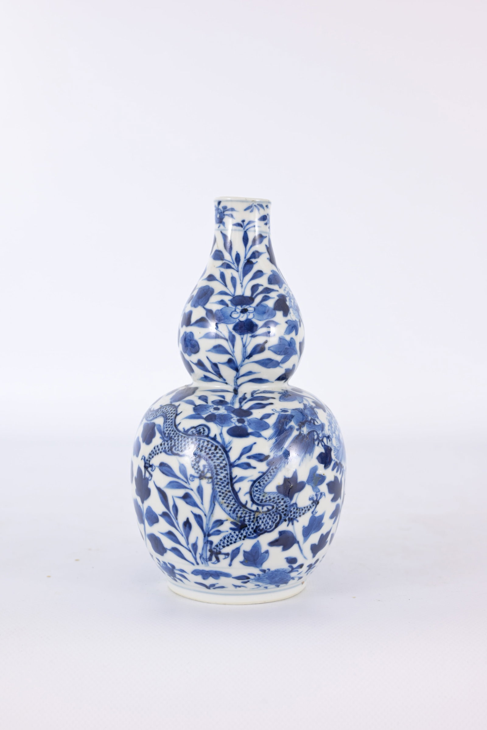 Chinese Blue/White Porcelain Dragon Vase: Chinese blue and white porcelain double-gourd dragon vase. Having mark on base which reads (Made during the Qianlong Reign). Height: 7.5 in.