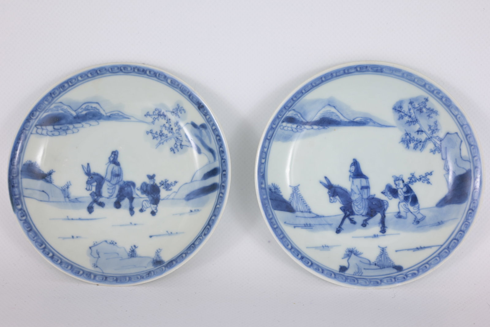 (2) Antique Chinese blue & white porcelain saucers: (2) Antique Chinese blue and white porcelain saucers. The hand-painted scene depicts the popular traditional narrative "Search for Plum-Blossom" (or Scholar and Donkey). It features a prominent