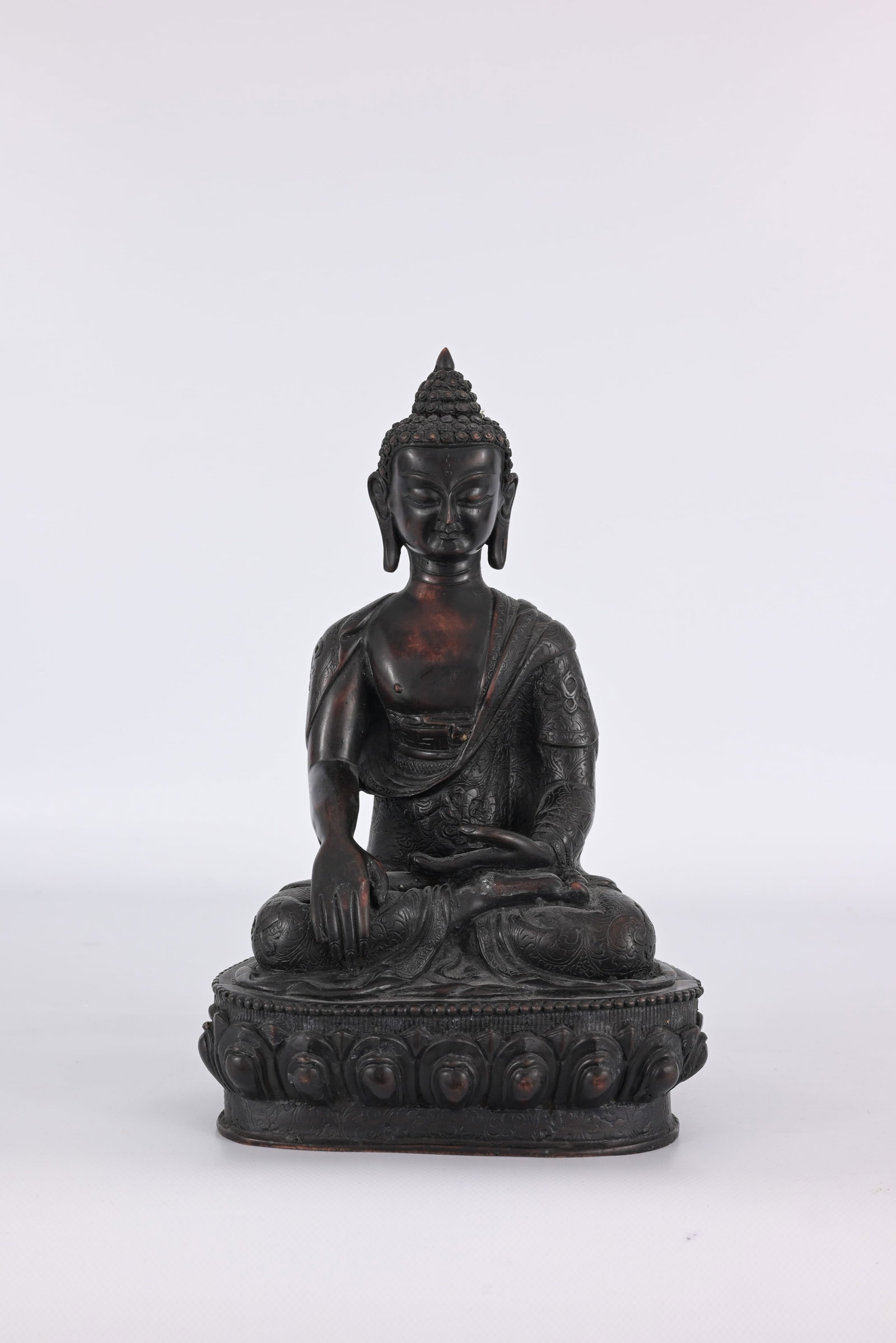 Statue of Shakyamuni Buddha: Statue of Shakyamuni Buddha seated in meditation on a raised lotus base. Made from resin. Height: 11 in.