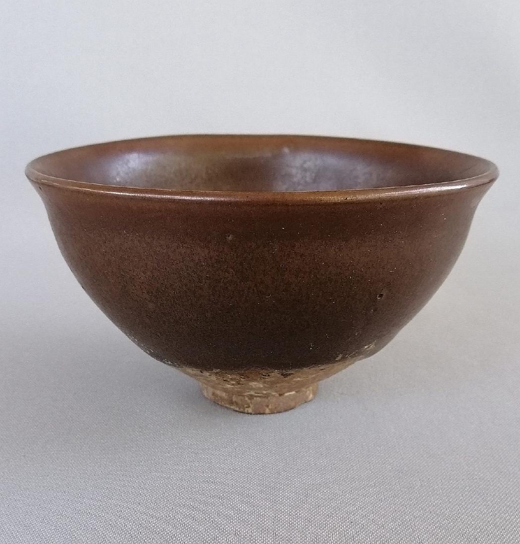 CHINESE SONG JIAN KILN SAUCE GLAZED BOWL: A nice Chinese Song dynasty Jian kiln sauce glazed bowl. Unsigned. Measures: H: 7.2 cm; D: 12.3 cm. Circa: Song dynasty or pre- 1800. Condition: Focal glaze loss and chip to foot rim. Typical wear com