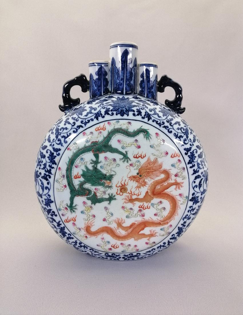 An elegant Chinese famille rose porcelain moon flk: An elegant Chinese famille rose porcelain moon flask decorated with one pink dragon and one green dragon striding in pursuit of a flaming pearl. MEASUREMENT: H: 25.8 cm; W: 31.2 cm. CIRCA: Qing dynast