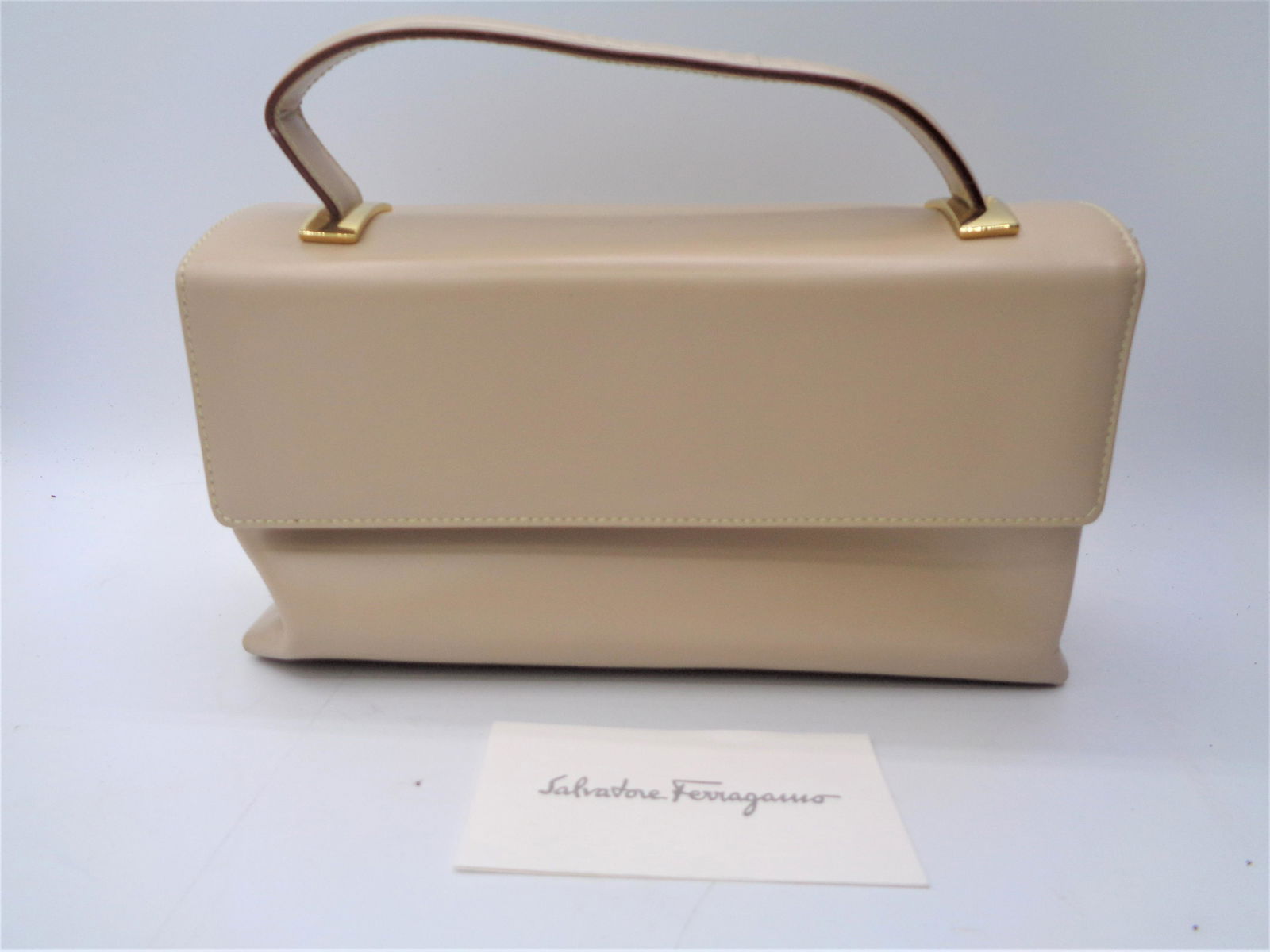Tan Ferragamo Clutch: With shoulder strap. Gold accents. Made in Italy.