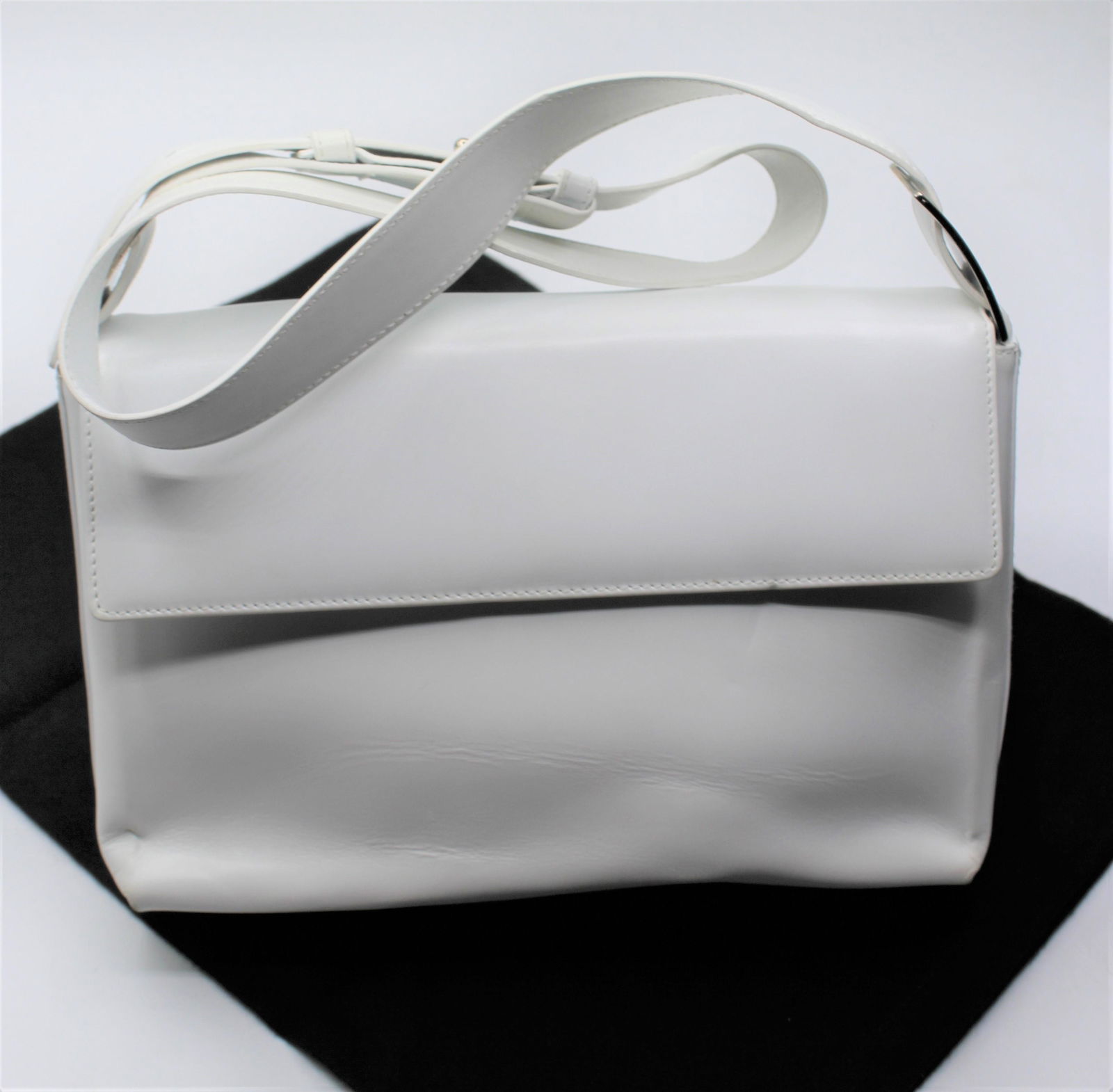 Ferragamo Whilte Shoulder Bag: Small white leather shoulder bag with silver accents. Button closure with interior zipper pocket. Small scuff mark located on back of bag. See photos