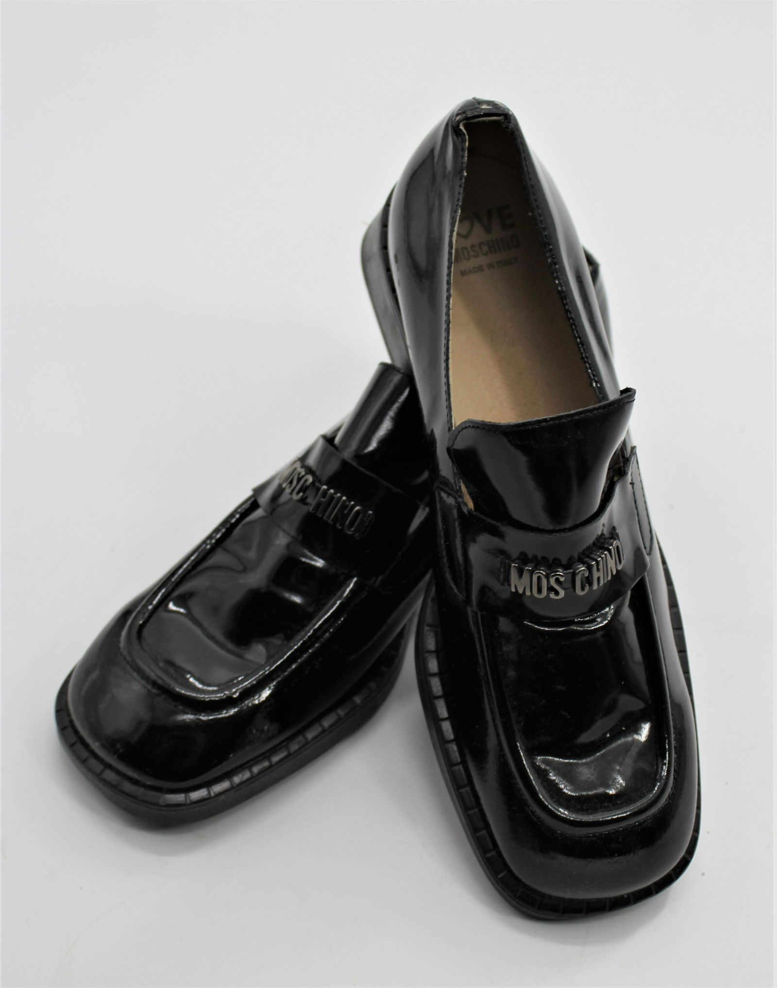 Moschino Women's Loafers: Black patent leather loafers, with silver Moschino band. Size 39.