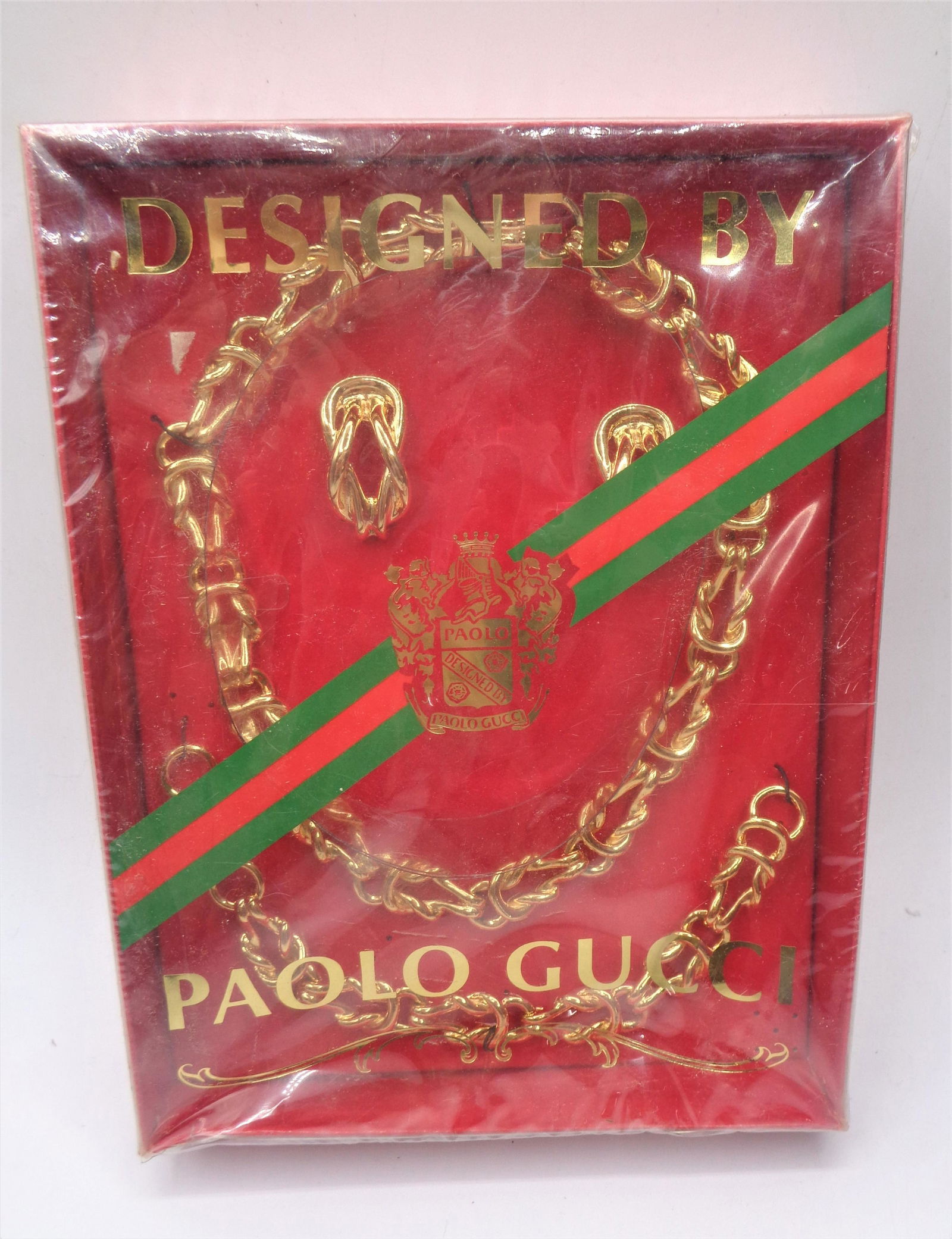 Paolo Gucci Jewelry Set: Brand new set in box. Designed by Paulo Gucci. Gold colored metal. Includes necklace, bracelet and earings.