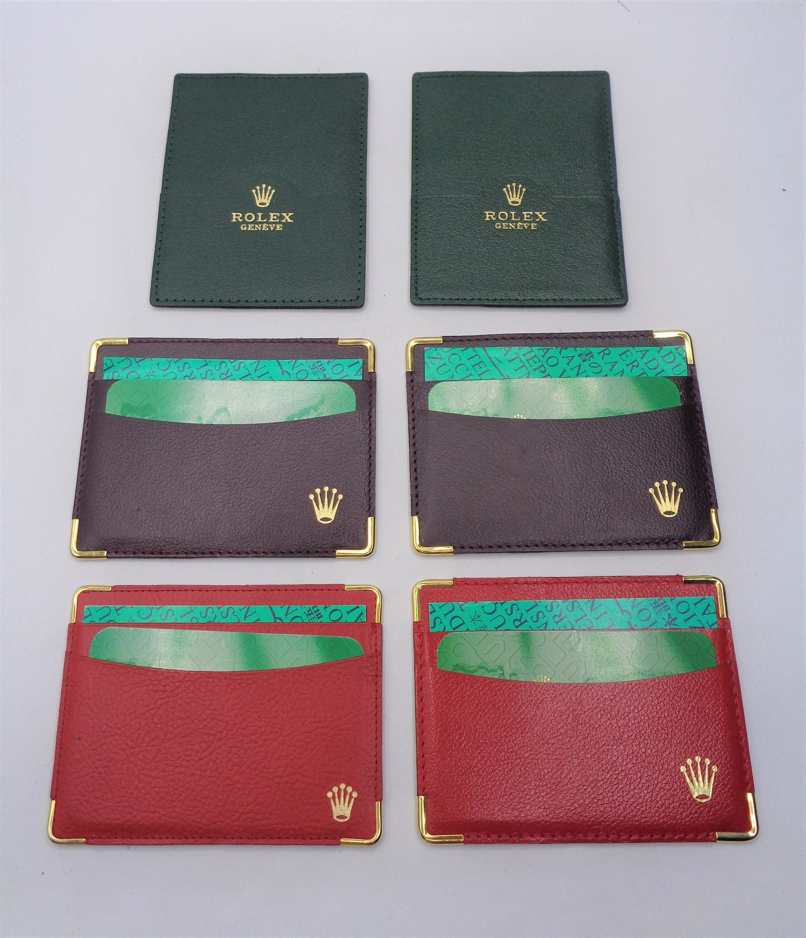 Lot of Rolex Wallets: 2 red, 2 brown, and 2 green square wallets. 4.75x3.50".