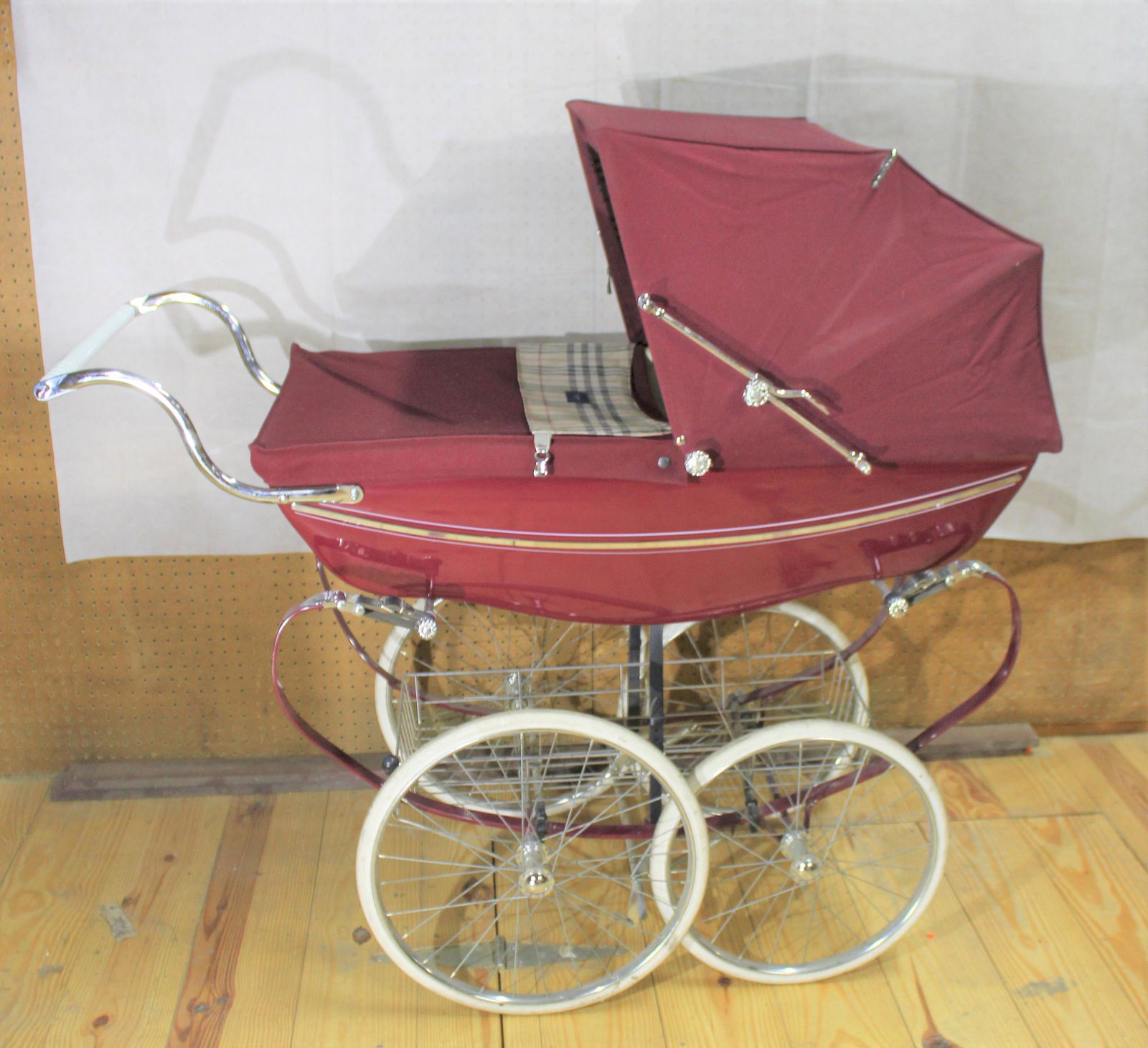 Burberry Wrapped Vintage Silver Cross Pram: Take a comfortable stroll with your bundle of joy in this stylish, vintage, Silver Cross baby pram. Large rubber Holland tires with chrome accents. Wrap consists of an authentic Burberry design, maroo