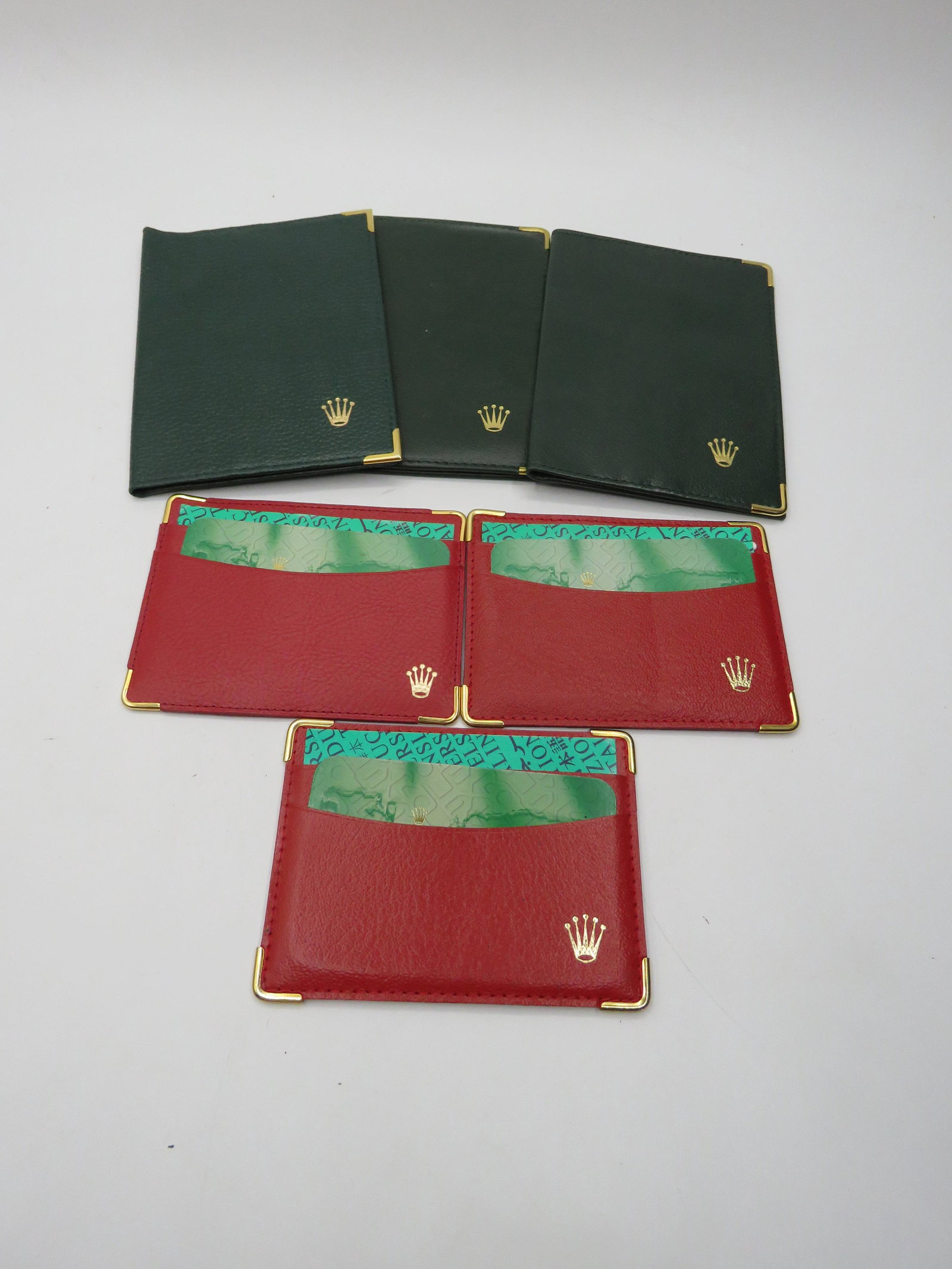 Lot of Rolex Wallets: 3 red and 3 green fold wallets. Red wallets 4.75x3.50". Green wallets - 4x5.75."