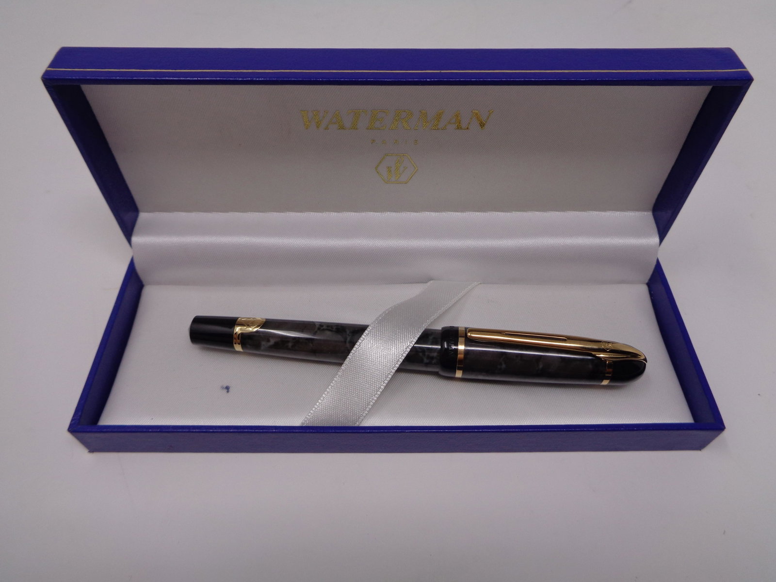 Waterman Paris Fountain Pen: Elegant Black/Gray Waterman fountain pen in original box. Beautiful gold accents. Pen stamped with Waterman. Item has a 5.25" Inch length. Excellent condition. Some minor staining on the inside of box