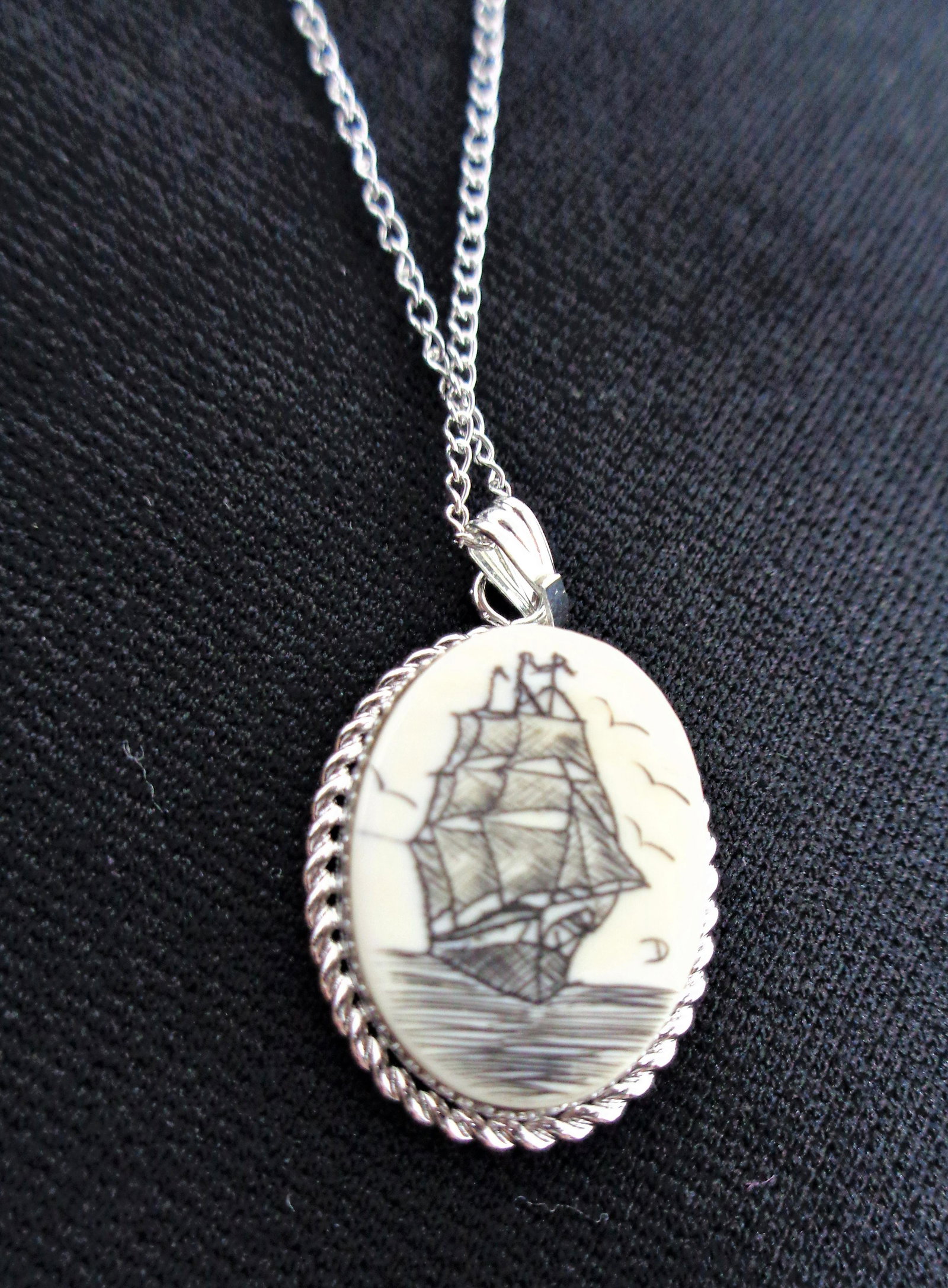 Vintage Scrimshaw Necklace.: Beautiful scrimshaw necklace with ship scene. Sterling silver chain and setting. The piece has a 10" inch drop when clasped. Perfect condition and comes with box and mini info book on the item. Pendan