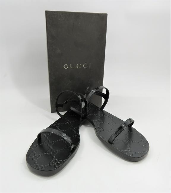 Gucci Womenâ€™s Sandals: Black, patent leather black â€œstrappy” sandals with gucci logo on sole. Made in Italy. Size 8.