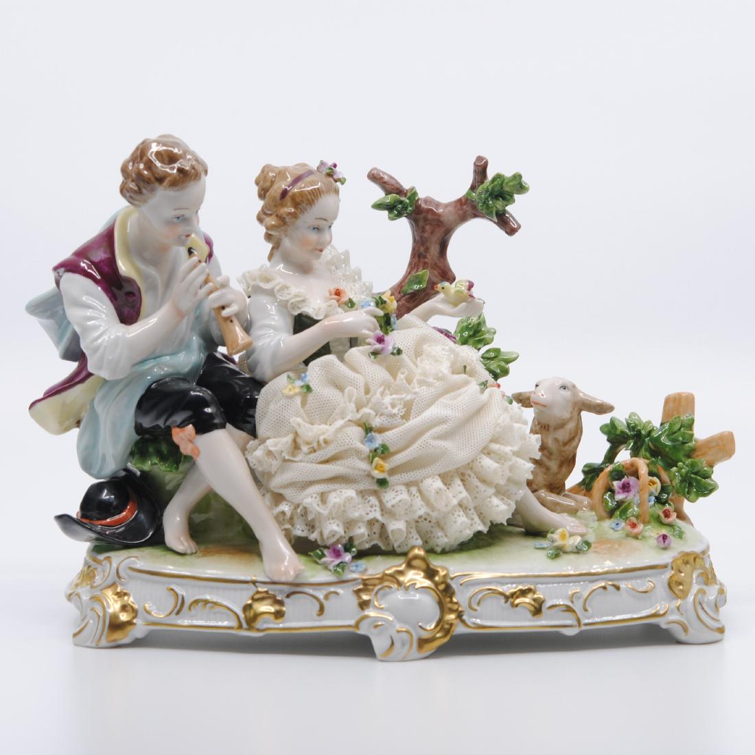 Unterweissbach "Flute Player & Girl with Lamb" Figurine: Unterweissbach "Flute Player and Girl with Lamb" hand crafted and hand painted porcelain figurine. This is a beautiful porcelain figurine of a man wearing a purple vest playing the flute for a woman s