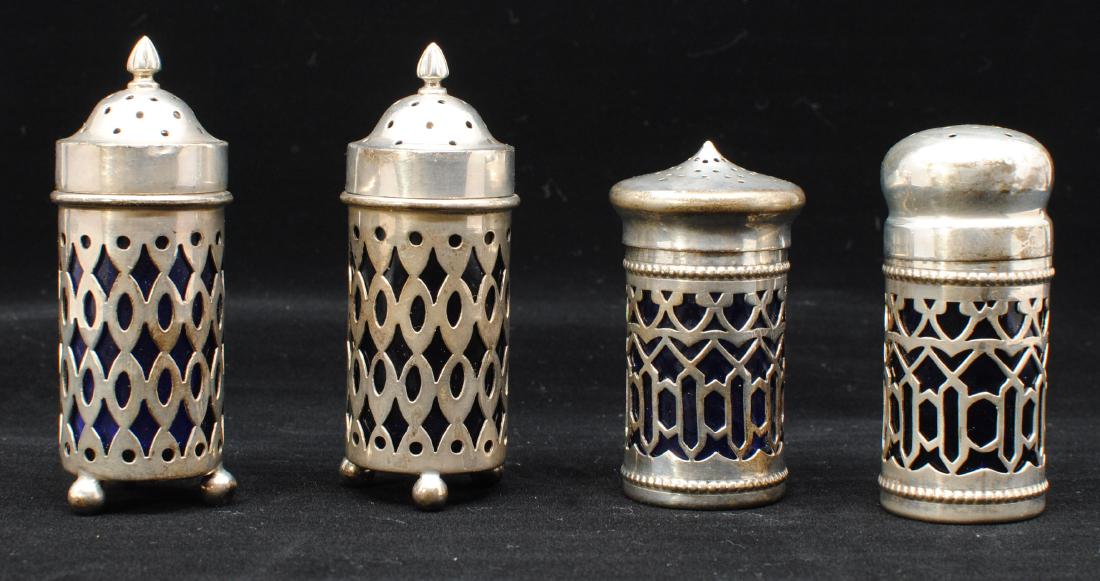 Sterling Salt & Pepper Shakers c.1900: Two sets (4 pieces) of American Sterling c.1900 salt and pepper shakers with vibrant cobalt glass inserts. Each set has its own beautiful intricate pattern. These are antiques with 'Sterling' stamped