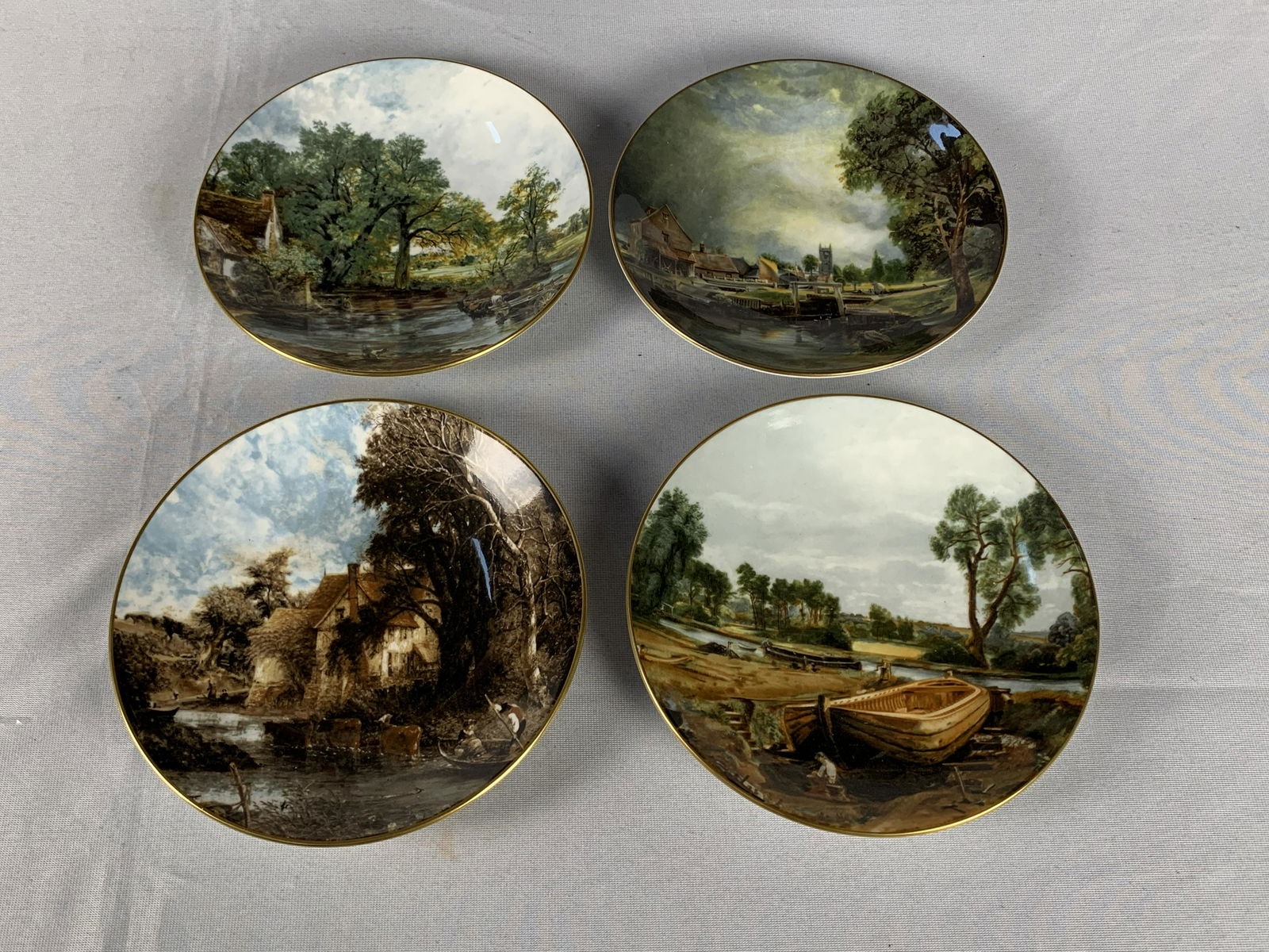 John Constable Collector Plates: A collection of 4 John Constable collector plates. Each is fine bone china, made by Crown Staffordshire. Plates include, "Valley Farm", "Boat Building Near Flatford Mill", Dedham Lock and Mill", and "