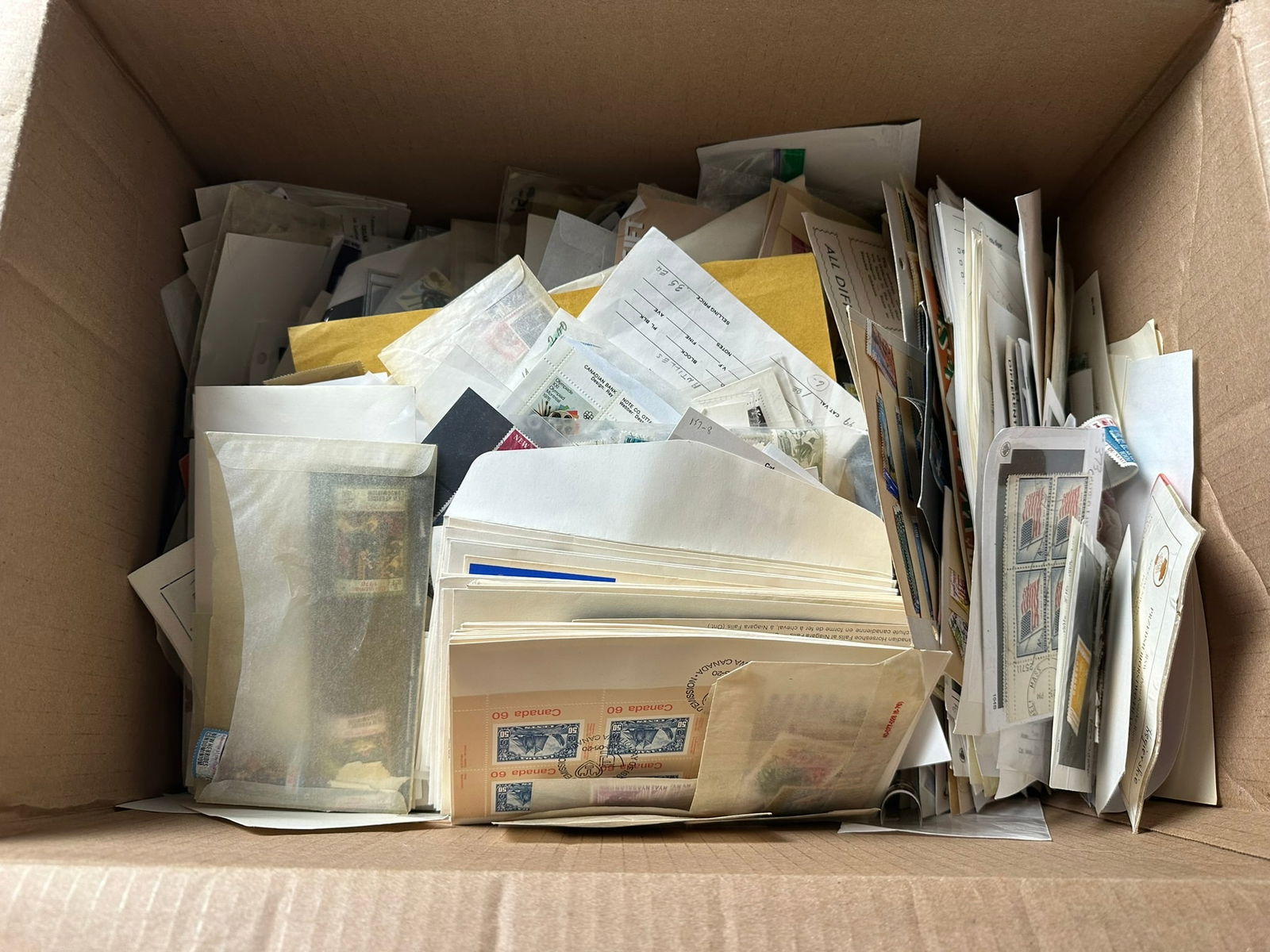 A large hoard of world stamps in 1000s of packets, contained in a large carton (1 of 6)