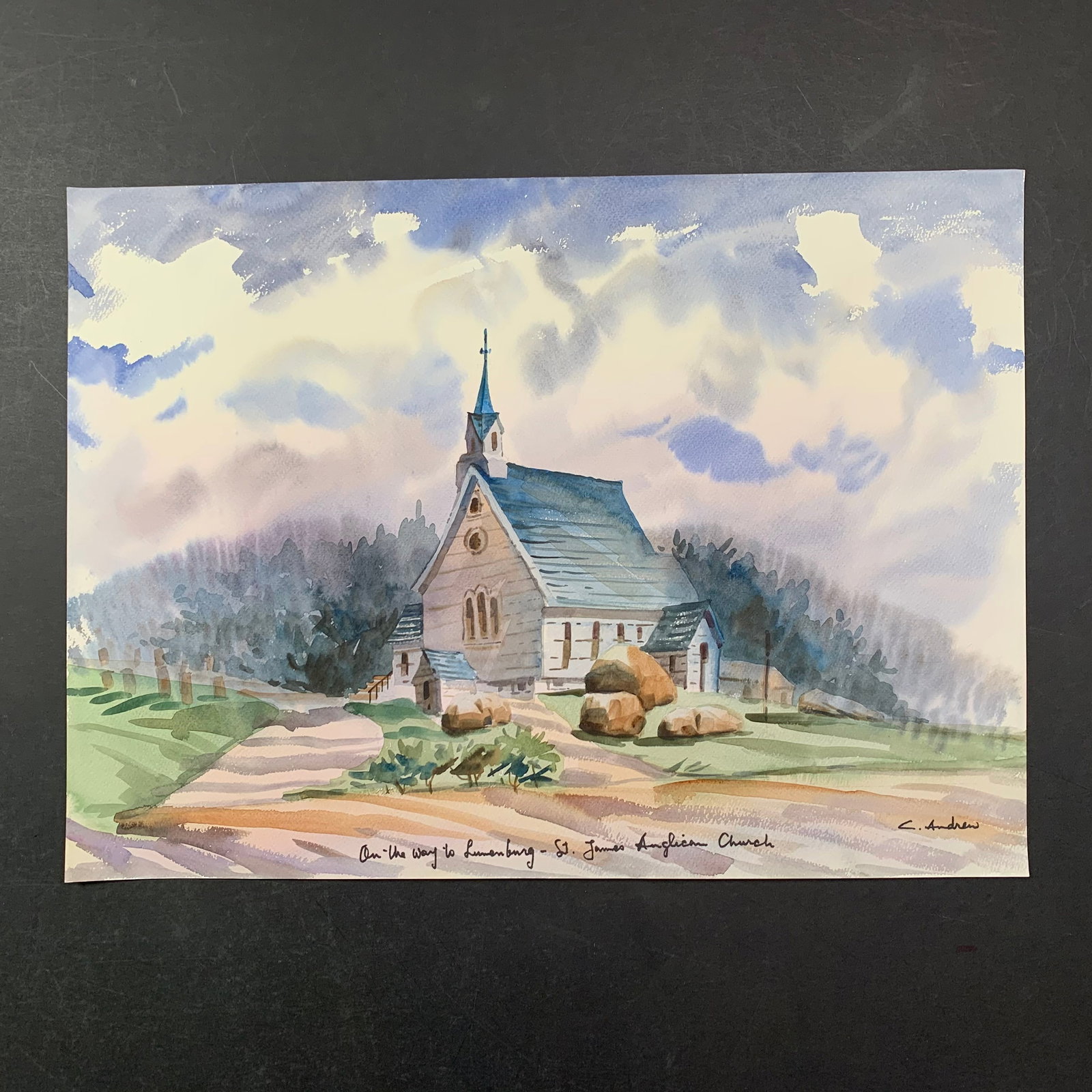 L. Marton's "On the Way to Lunenberg - St. James Anglican Church" Original Print: L. Marton's "On the Way to Lunenberg - St. James Anglican Church" original print. This piece is of St. James church, with a forest in the background, done in a watercolour style. This piece is in exce