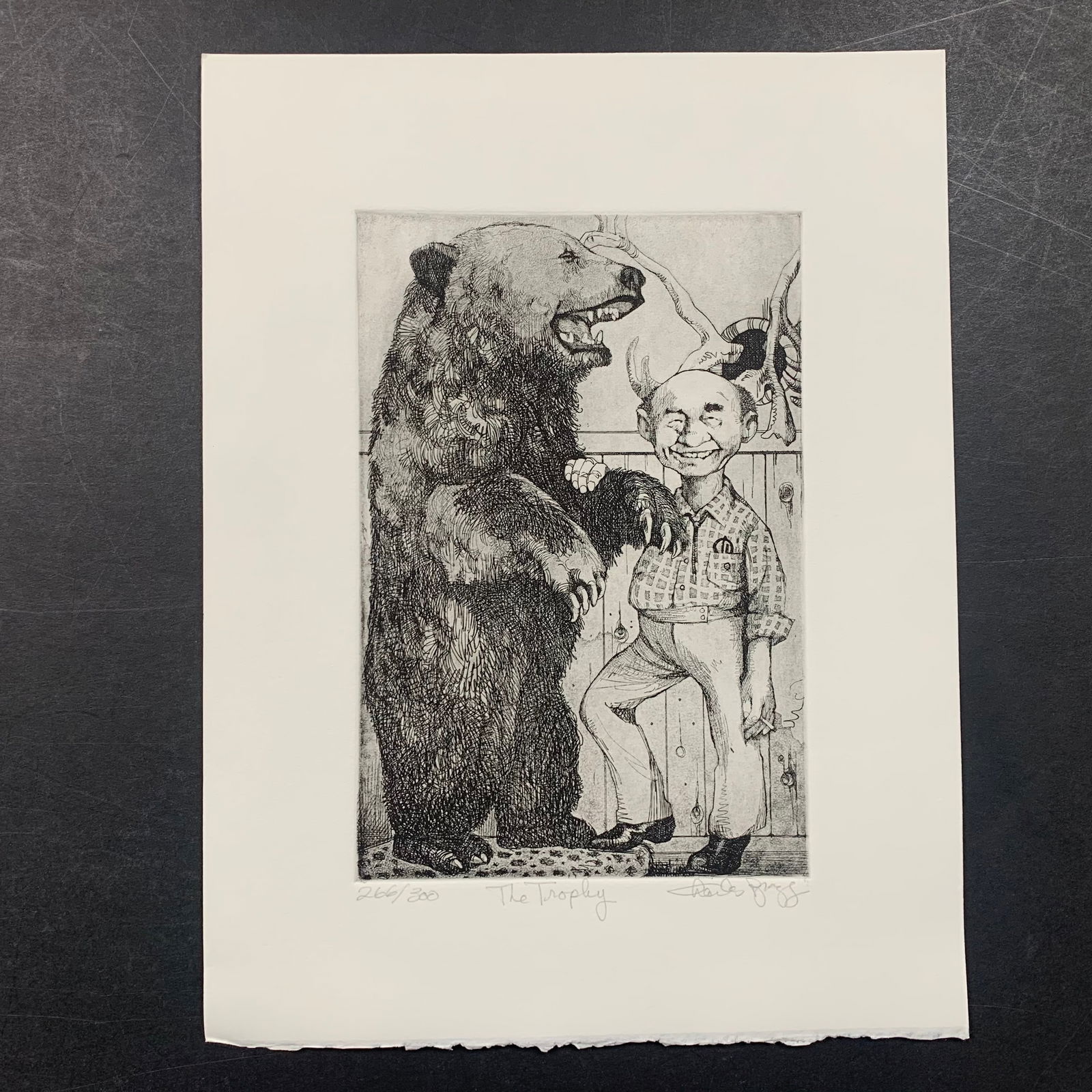 Charles Bragg's "The Trophy" Limited Edition Print: Charles Bragg's "The Trophy" limited edition print, signed lower right and numbered 266/300 lower left. This piece is of a hunter who is showing off his large taxidermied bear. This piece is in excell