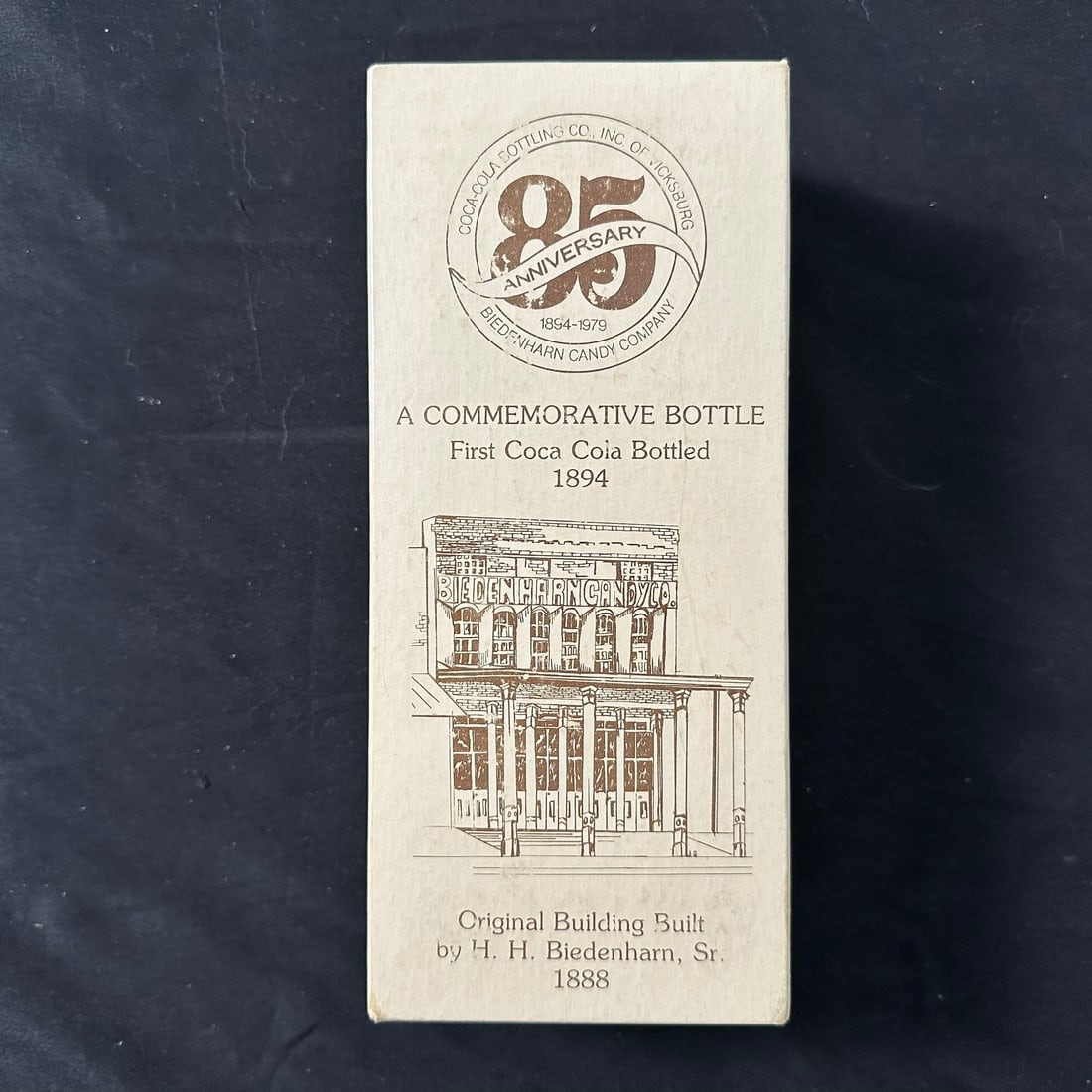 Coca Cola Commemorative 85th Anniversary Biedenharn Candy Company Glass Bottle: Coca Cola Commemorative 85th Anniversary Biedenharn Candy Company glass bottle with its origianl box. Box shows very minor signs of wear. Collectibles, Vintage Box: 4" x 2 1/2" x 9 1/2" tall.