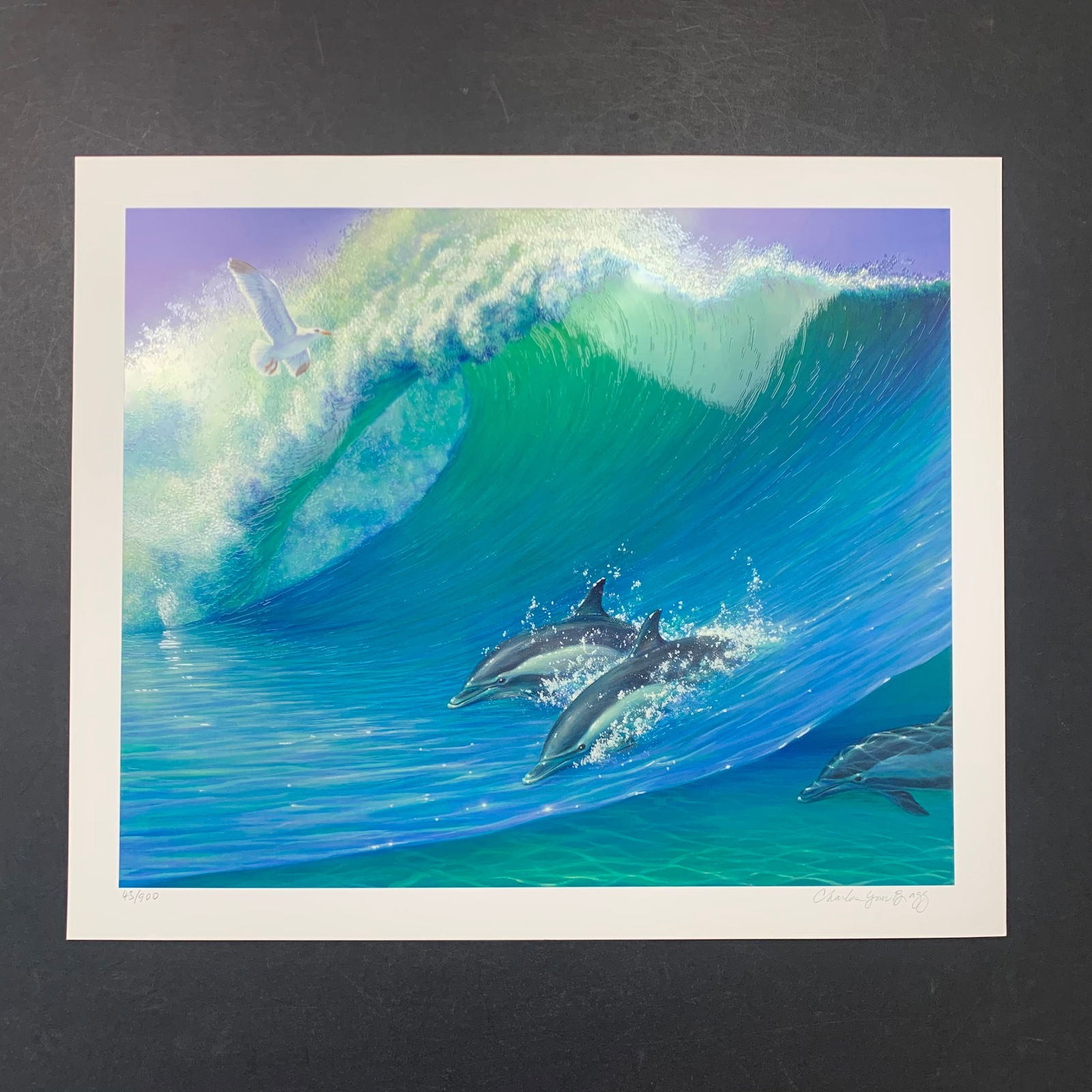 Charles Lynn Bragg's "Under the Waves II" Limited Edition Print: Charles Lynn Bragg's "Under the Waves II" limited edition print, signed lower right, and numbered 43/900. This piece is of a few dolphins in the water riding a wave, with a seagull in the air. This pi