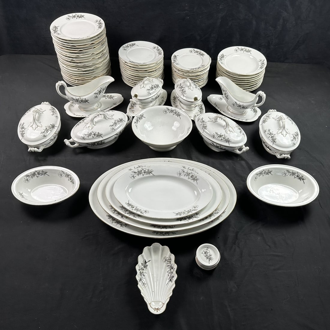 Exceptional Antique European Porcelain Dinner Service with Monochrome Floral Garland and Gilt: Presented here is an exceptionally elegant and highly decorative antique European porcelain dinner service, executed in refined white porcelain and adorned with delicate hand painted gray floral garla