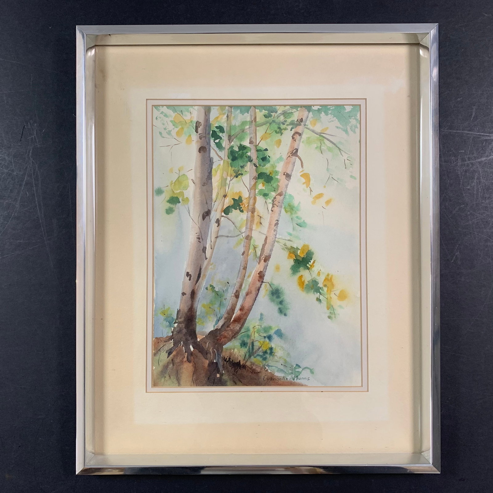 Evangeline Munns Original: An Evageline Munns original watercolour on paper, signed lower middle. This piece is of a skinny tree, with green and yellow leaves. This piece is in excellent condition and has been custom framed und
