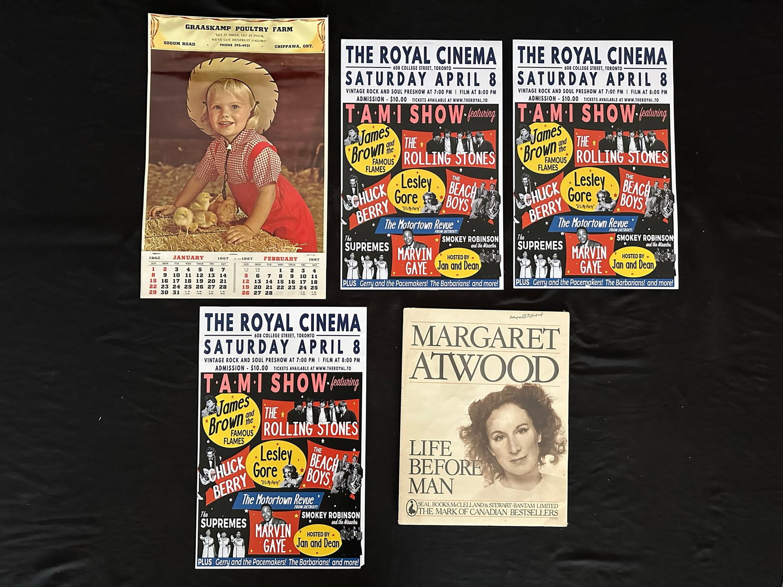 Various Posters: A grouping of various posters including Margaret Atwood "Life Before Man" autographed (wrapped in shrink wrap), Graaskamp Poultry Farm 1967 advertising calender (with each month still intact at bottom