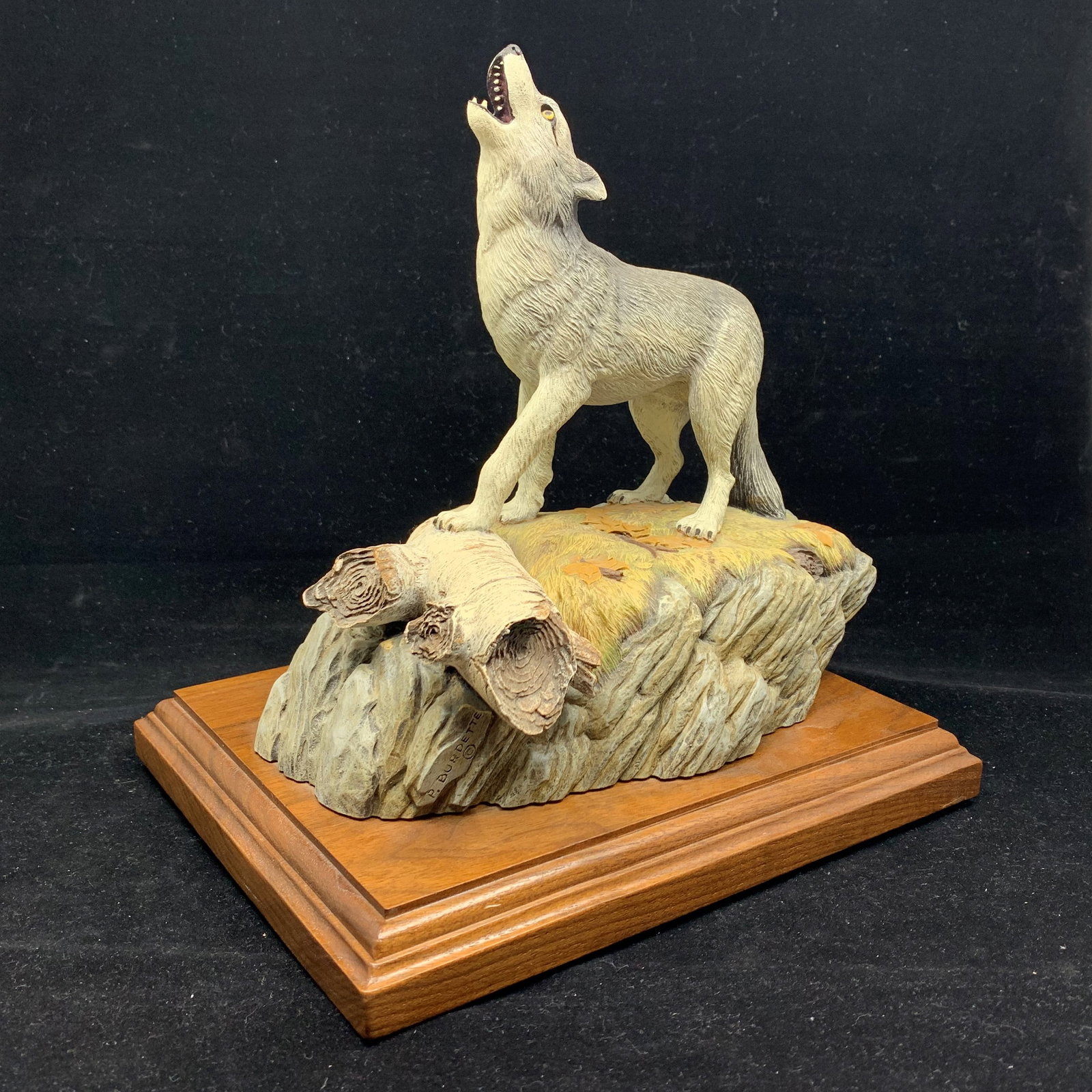 Paul Burdette's "Wolf" Limited Edition AP Sculpture: Paul Burdette's limited edition wolf carving, signed and numbered on the bottom, Artist Proof AP 8/15. This wolf is howling with its head back, and has its front paw on a branch. The wolf is mounted