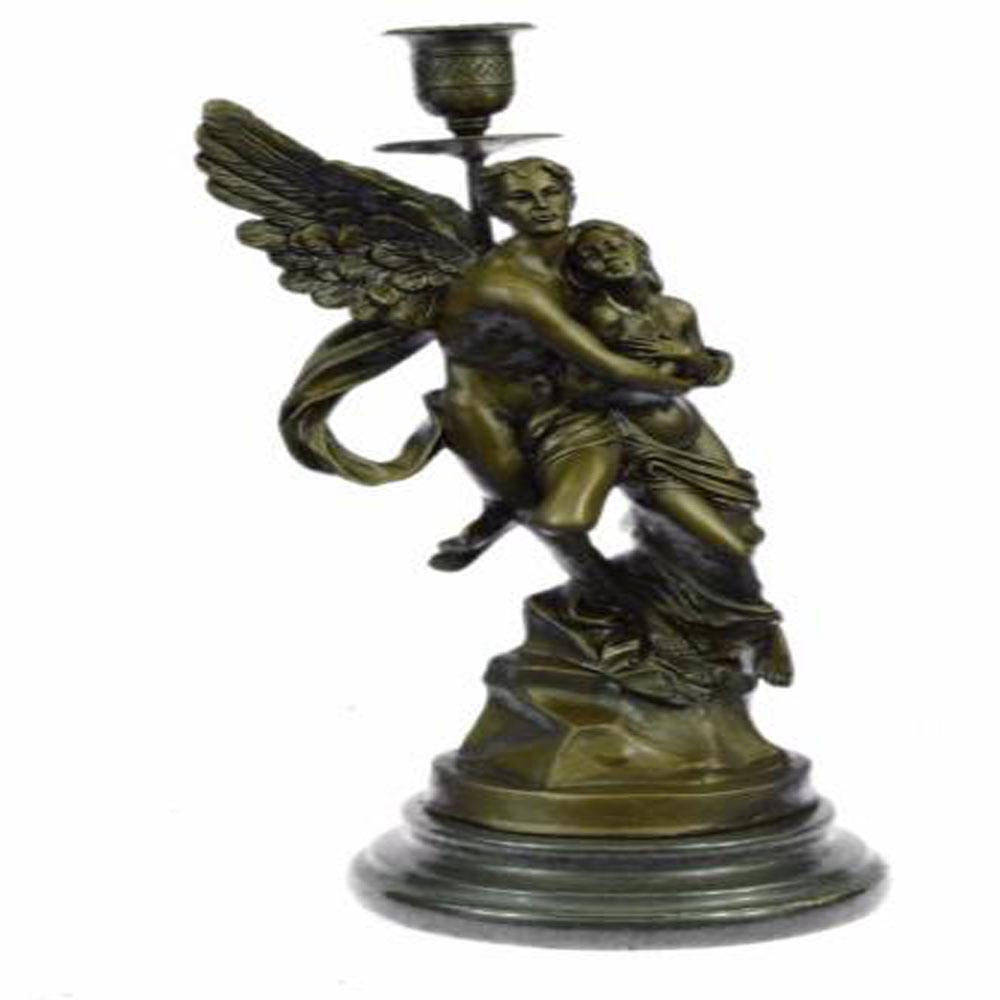 Eros and Psyche Romantic Candle Holder Bronze Sculpture: A nude male angel carries a nude girl and in his arms. The girl clutches her bare chest as she head tilts up to her lover and protector. They are almost nude with only a cloth lightly draped over the 