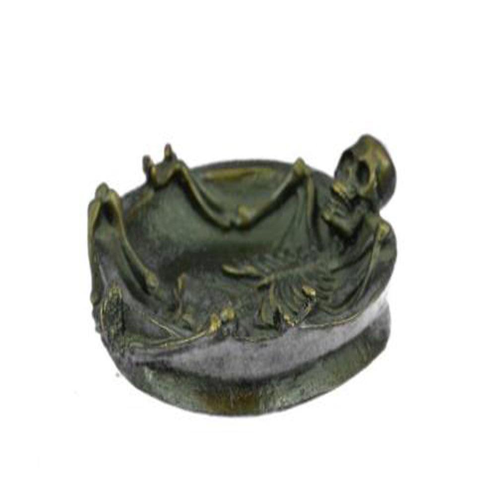 Full Skeleton Emerges from Ashtray Bronze Sculpture: The sculptor has taken the concept of an ashtray and completely transformed it. A full skeleton emerges from the dish. Its legs hang over the edge eerily coming together at the feet. Every bone and jo