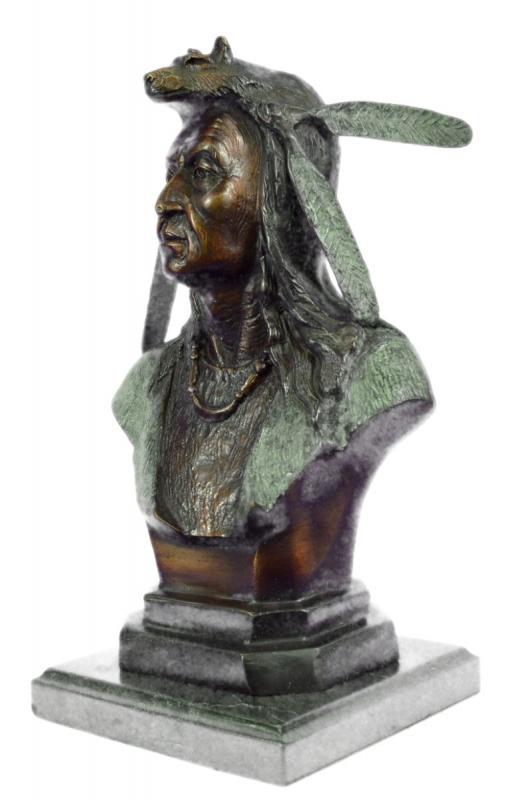 Native American Bust Bronze Sculpture: A seasoned elder of his tribe, this Native American stands proudly as a symbol. This bust sculpture depicts a tribe leader, cloaked in a wool shawl and animal skin. The clothing of Native Americans wa