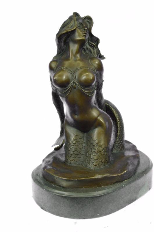 Mermaid Bronze Sea-life Sculpture: Sea-life Sculpture of a realistic mermaid sitting while holding her tail. The mermaid Sculpture is also designed for placement on a shelf to brighten up the room. This brown Bronze patina was crafted