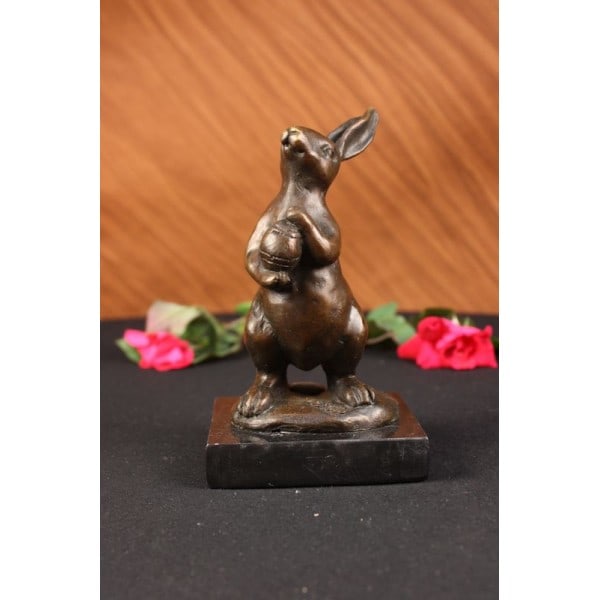 Mini Easter Bunny Bronze Sculpture: This cute and cuddly Lil lady looks up with the sweetest look and holds a tiny basket full of flowers in her tiny arms. This little bunny is the perfect touch of decor for a sweet and cute look. Her e