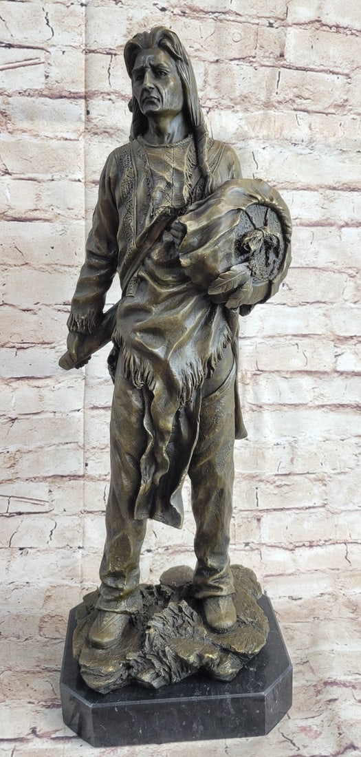 Chief With Shield Gun Full Headdress Bronze Statue: This impressionistic Sculpture of the Indian chief instills a sense of pride, respect, and honor. He has a traditional necklace. His hair is straightened and falls onto his back. His face is old and w