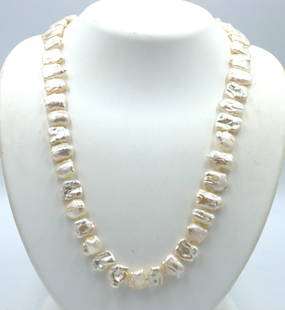 Creamy pearl strand necklace with Jade clasp: Creamy pearl strand 34-inch necklace with 14kt yellow gold Jade clasp. The total weight of the necklace is 88.5 grams.