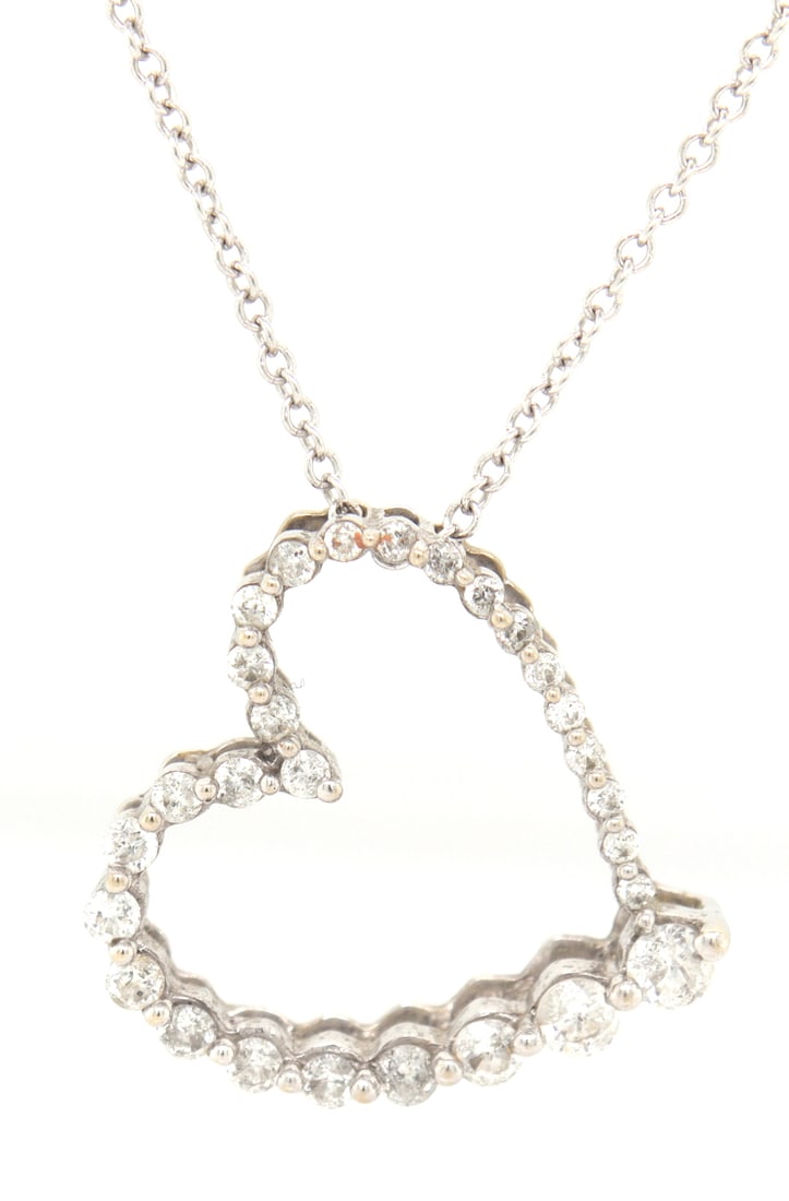 14kt White gold shared prong open heart pendant on chain: 14kt White gold approximate 0.25ctw diamond shared prong open heart pendant on 18 inches chain necklace. Color I-J. Clarity I1. Total weight of necklace is 3.30 grams.