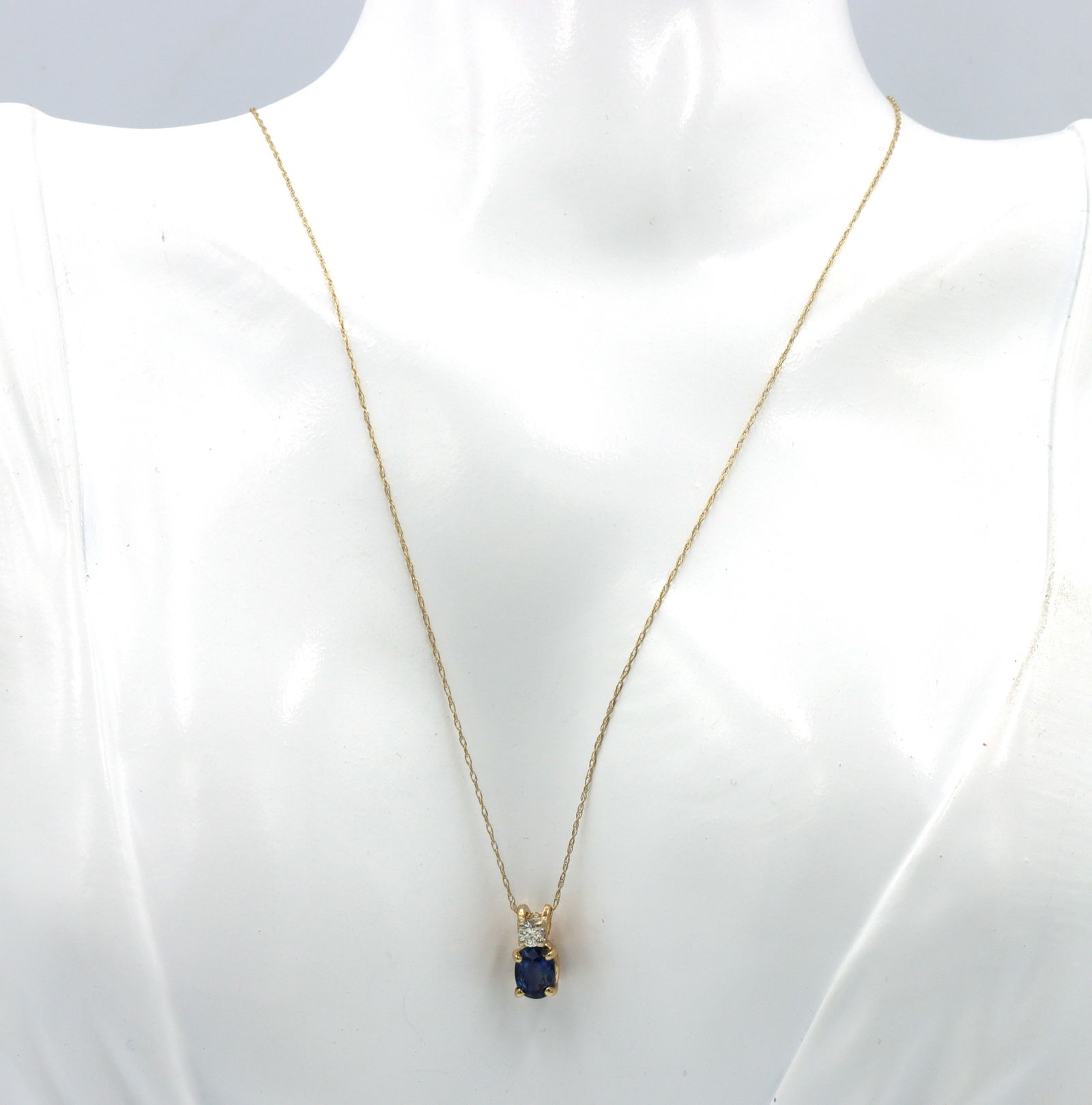 14kt Yellow gold 1.10ct oval sapphire and diamond pendant on chain: 14kt Yellow gold approximate 1.10ct oval blue sapphire and 0.12ctw round brilliant cut diamond pendant on 18-inch chain necklace with spring ring clasp. The total weight of the necklace is 1.20 grams.