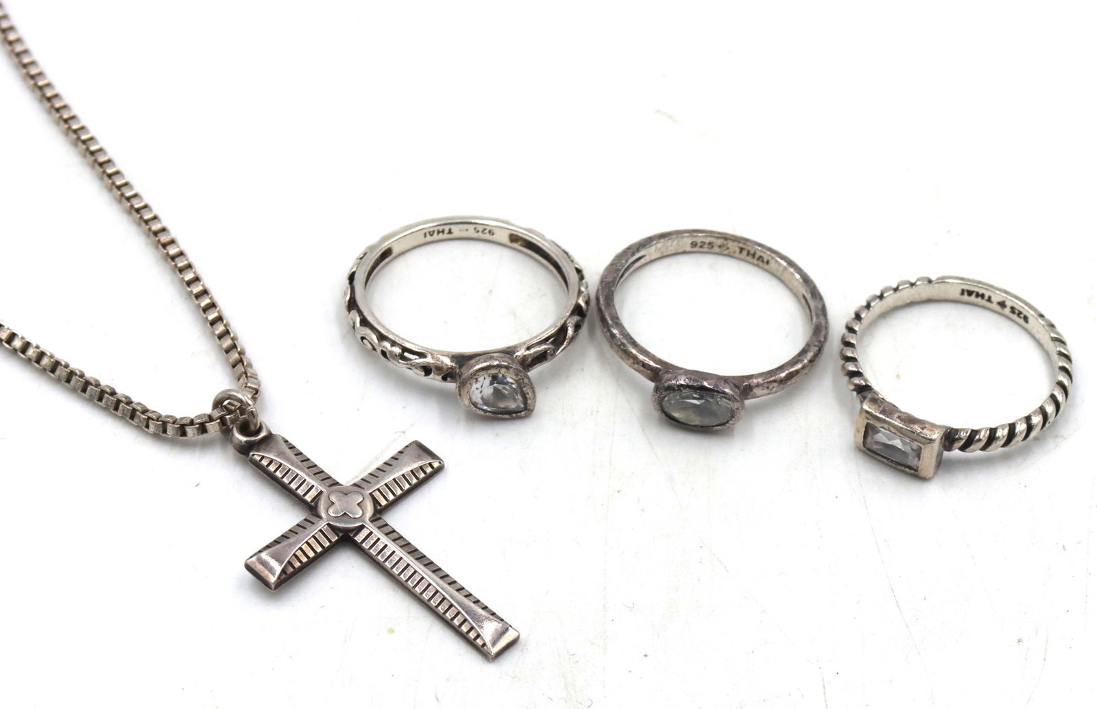 Group lot of vintage 925 sterling silver mixed jewelry: Group lot of vintage 925 sterling silver mixed jewelry. 3 Rings, Cross pendant on 20-inch Italian box chain necklace. The total weight of the lot is 14.20 grams.