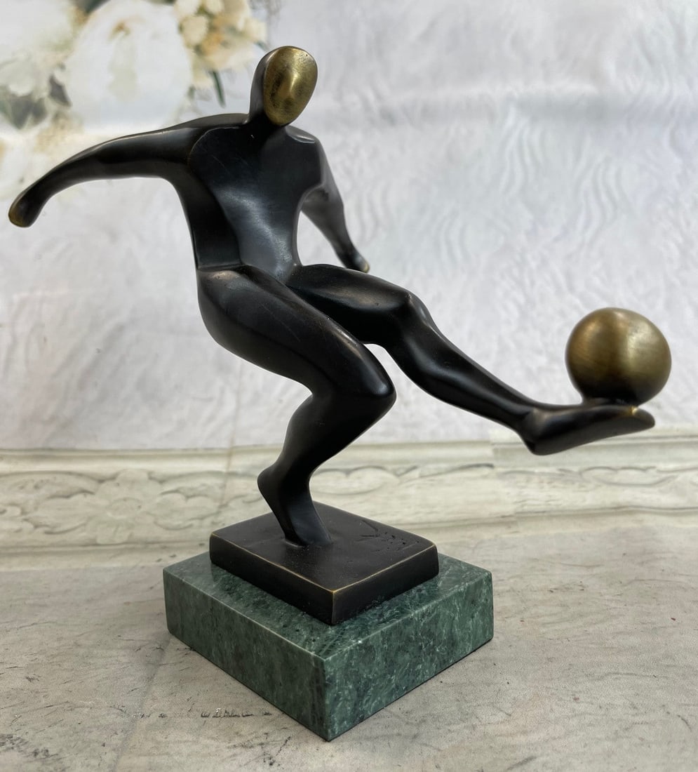 Modernist of Soccer Player Bronze Sculpture: A soccer player tumbles down the grassy field, kicking, and dodging along the way. He is swift on their feet. One nears the goalpost and lunges one leg forward, propelling the ball towards the net. He