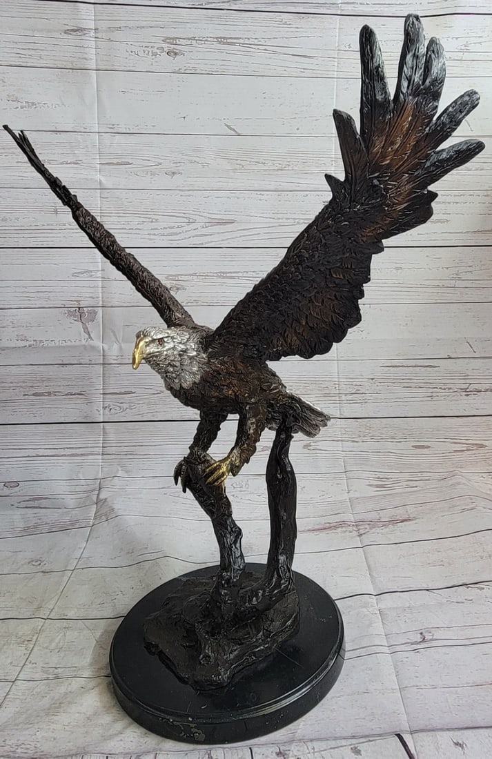 Stunning Eagle Bronze Statue: A fascinating and eye-catching sculpture. A large eagle spreads its wings and prepares for flight after catching its prey. In his talons, he clutches a fish he has plucked from the cool water. Eagles