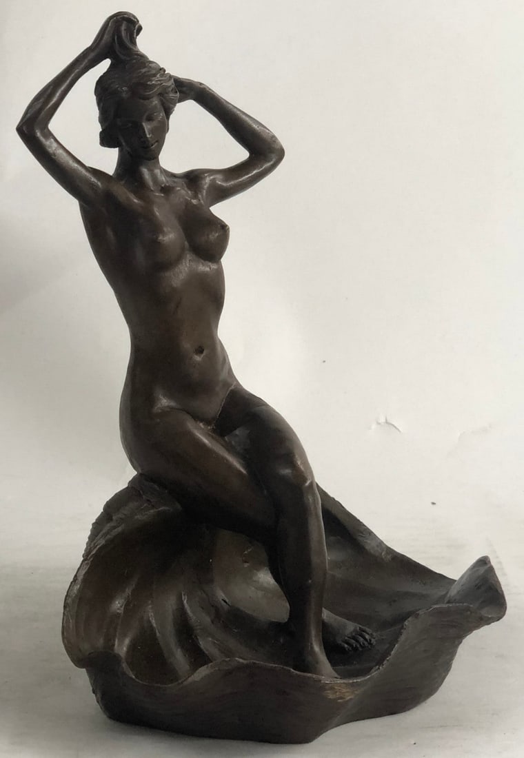 Jewelry Tray Bronze Sculpture: A sensuous nude woman rests on a flower. She stares wistfully beyond her brushing her luscious locks with her fingertips. The flower she sits upon is a large blossomed flower bud. She sits on its edge