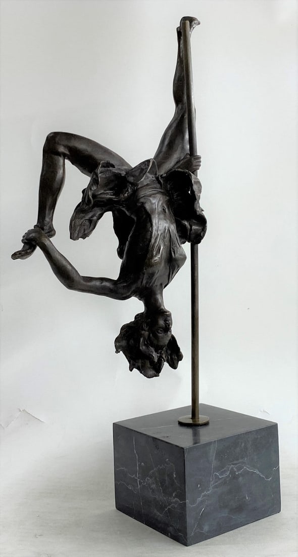 Gymnast Acrobat Bronze Sculpture: This woman is a talented Gymnast demonstrating her agility and flexibility. Balancing on a pole as she has trying to amuse you. Her muscular legs curve backward and rest in her hands on her shoulders.
